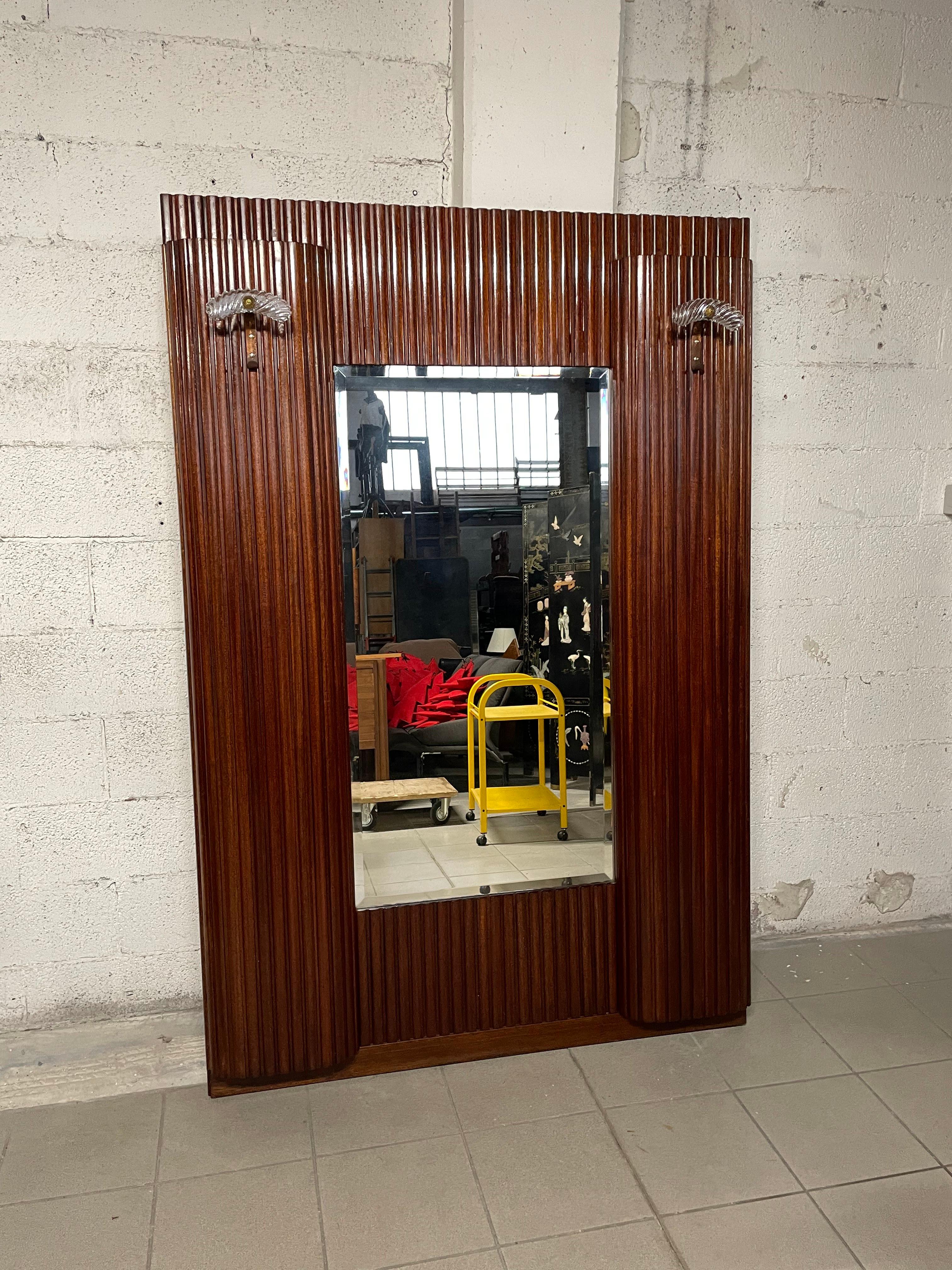Mobile appendiabiti con specchio centrale risalente agli anni '30/'40.

Ai lati sono presenti due ante bombate celanti una parte interna a ripiani e scomparti.
Nella parte esterna sono presenti anche due appendini in vetro e ottone sempre del