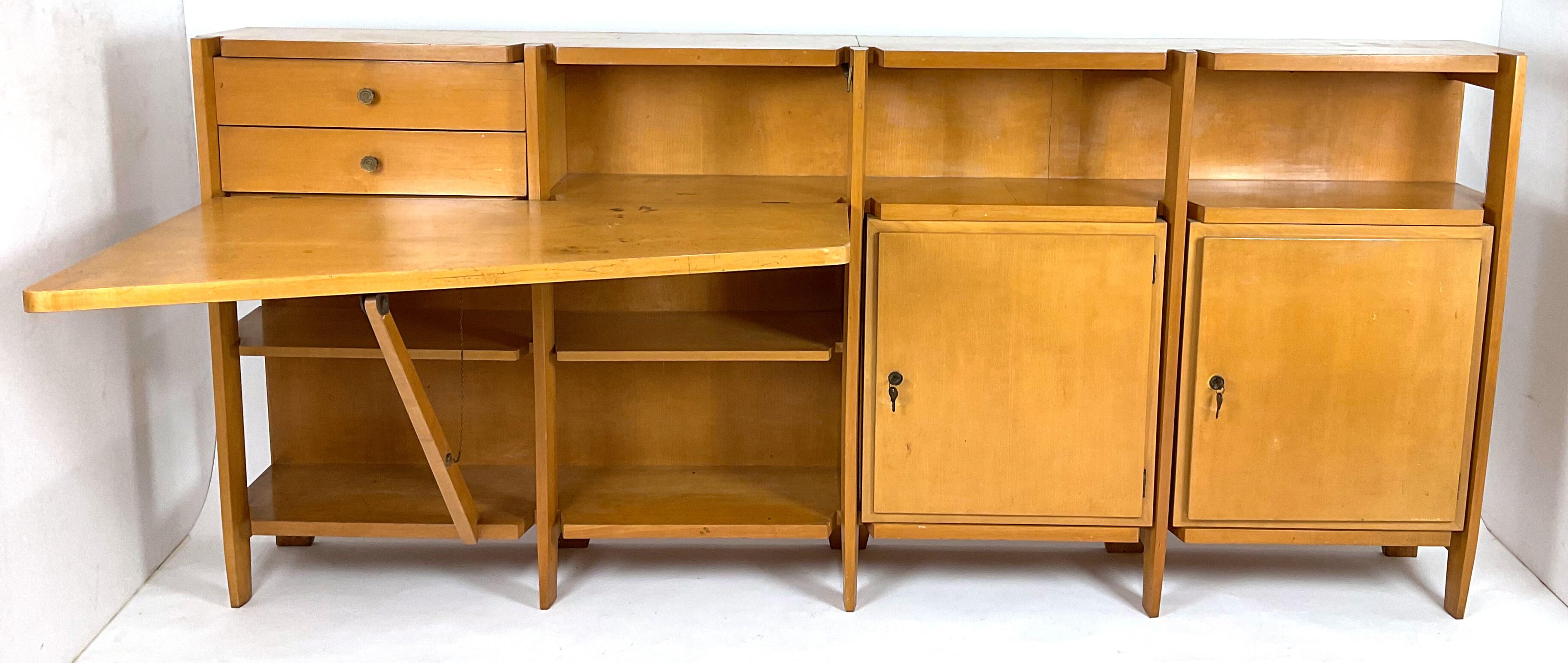 This extraordinary storage cabinet with drop-down desk and hanging shelf/bookcase, made in the 1950s, is a unique example of 20th-century Italian craftsmanship excellence. The frame, made of fine blond wood, is enriched with elegant brass details