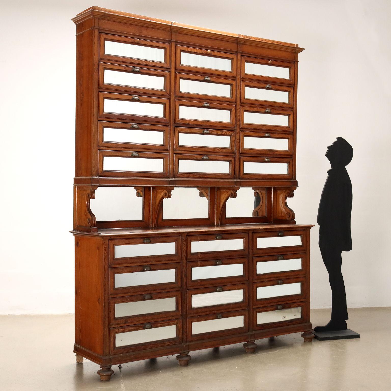 Large store cabinet made of larch wood, consisting of four rows each with three drawers in the lower body, while in the riser there are five rows. Made of larch wood, the front of each drawer as well as the panels at the bottom of the compartment