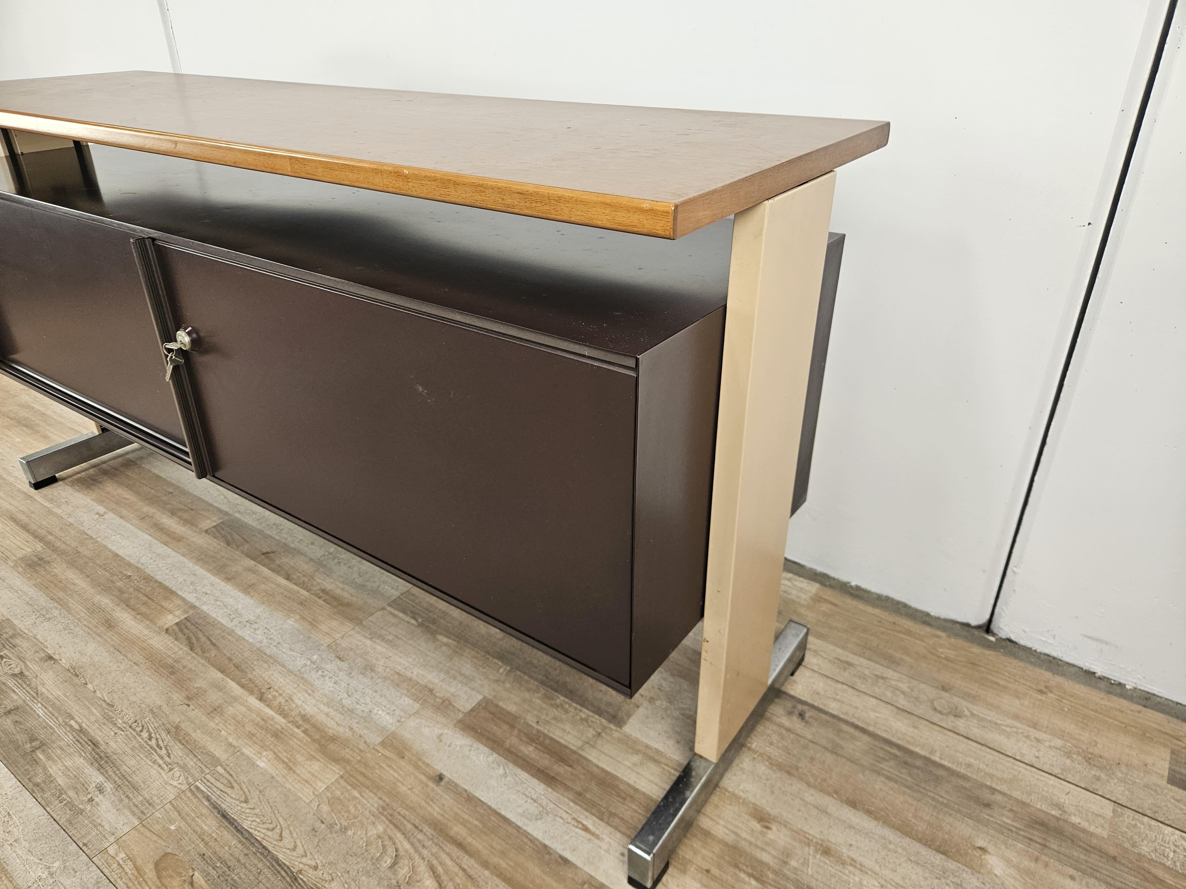 Mobile da ufficio con doppia anta scorrevole e piano in laminato di legno, produzione italiana anni '70 firmata Olivetti.

Presenta normali segni dovuti da età e utilizzo.