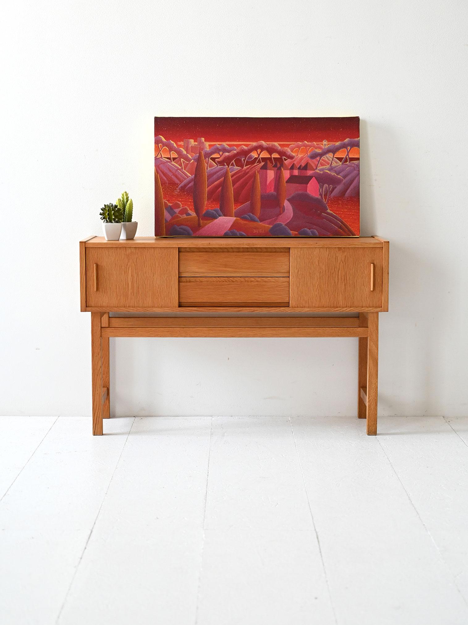 1960s light teak cabinet with two side compartments and central drawers. Light lines and subtle sculptural handles.

Scandinavian light teak entry cabinet from the 1960s, with a geometric frame and raised off the floor. Two side compartments with
