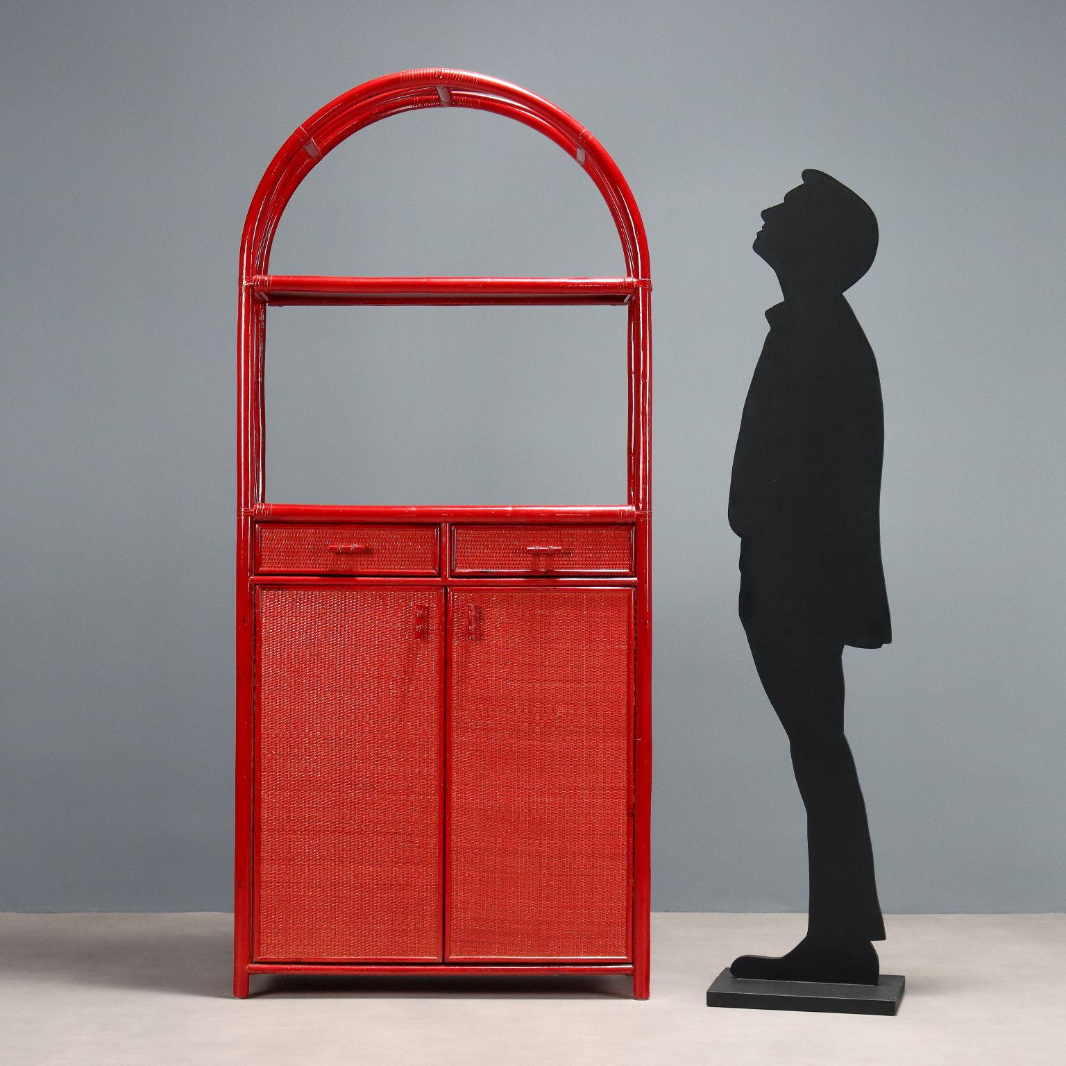 Mobile libreria vintage realizzato in bambù smaltato rosso con ante a battente, cassetti e ripiano in vimini con vetro in appoggio.
