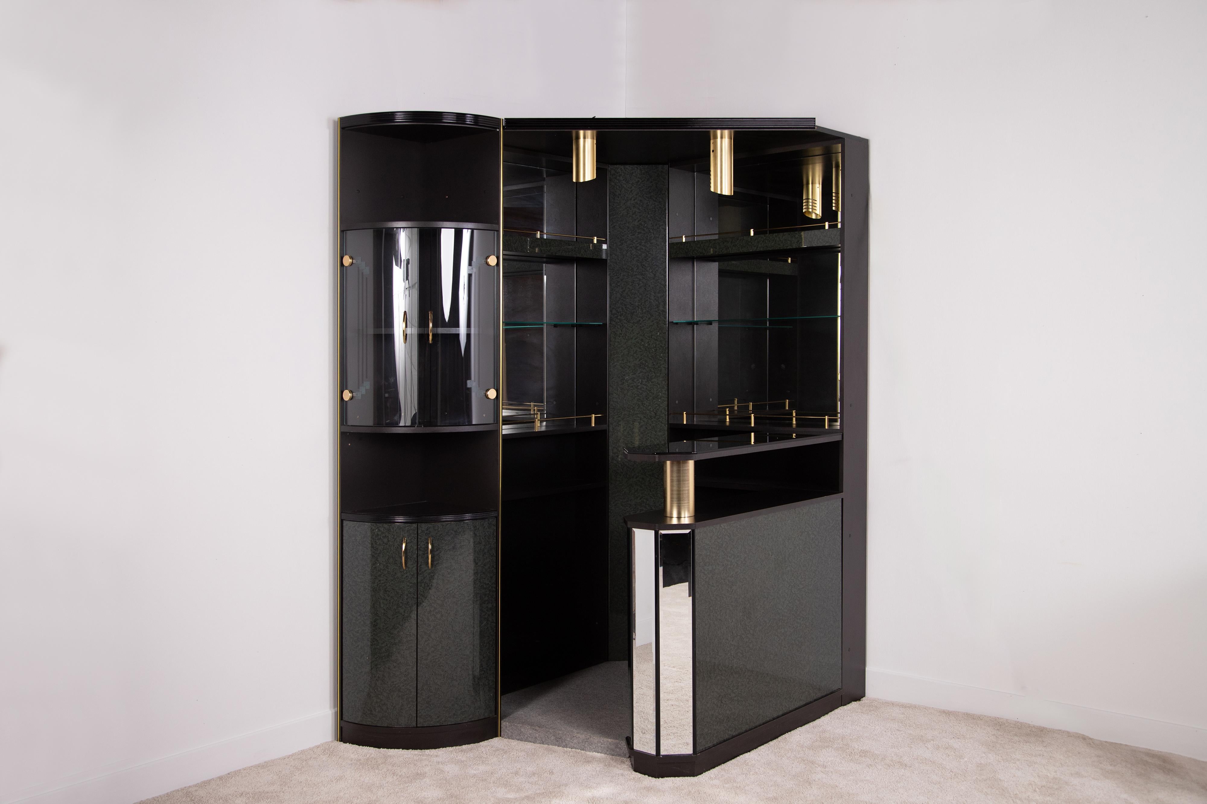 Italian-made 1980s corner bar wall in excellent condition. Made of black laminated wood and petrol-colored burl effect. There are capacious shelves and compartments and two light points. This is a post modern and simultaneously very glamorous piece,