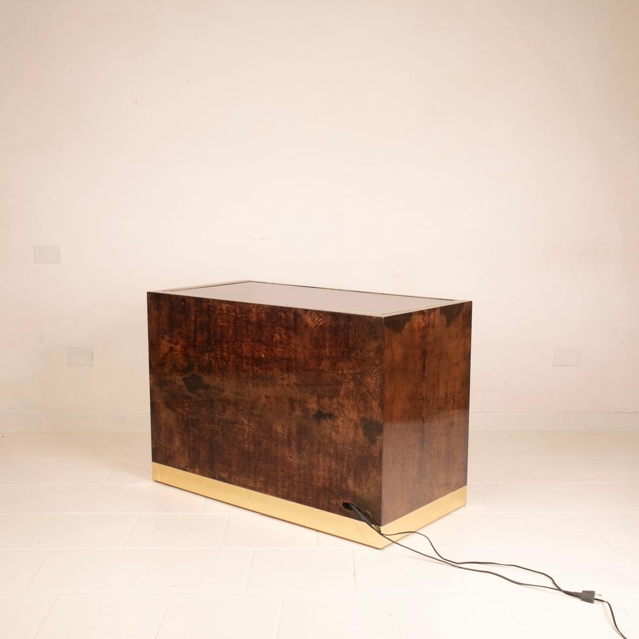 Very rare radio and DJ cabinet designed and produced by Aldo Tura for the Tura Milano company of the same name in the late 1960s.
The cabinet is entirely upholstered in tobacco-dyed goatskin, or parchment leather,  with details, profiles and