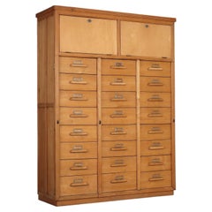 A wooden filing cabinet from the 1950s with numerous drawers.