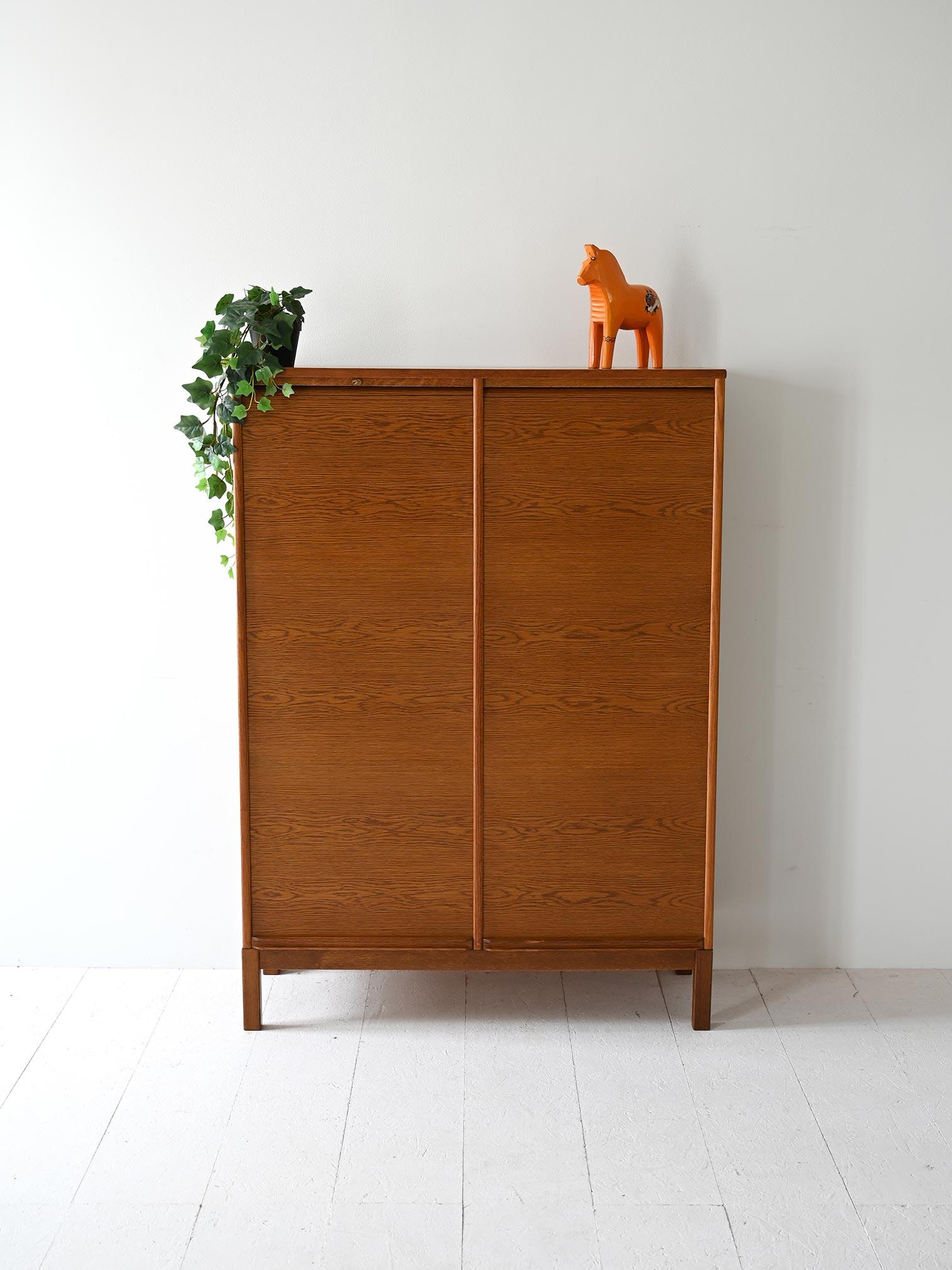 Vintage 1960s filing cabinet with double shutter doors and interior with shelves.

The double shutter doors slide vertically to reveal spacious and organized interiors with practical shelves. Ideal for studies, offices or living rooms, it perfectly