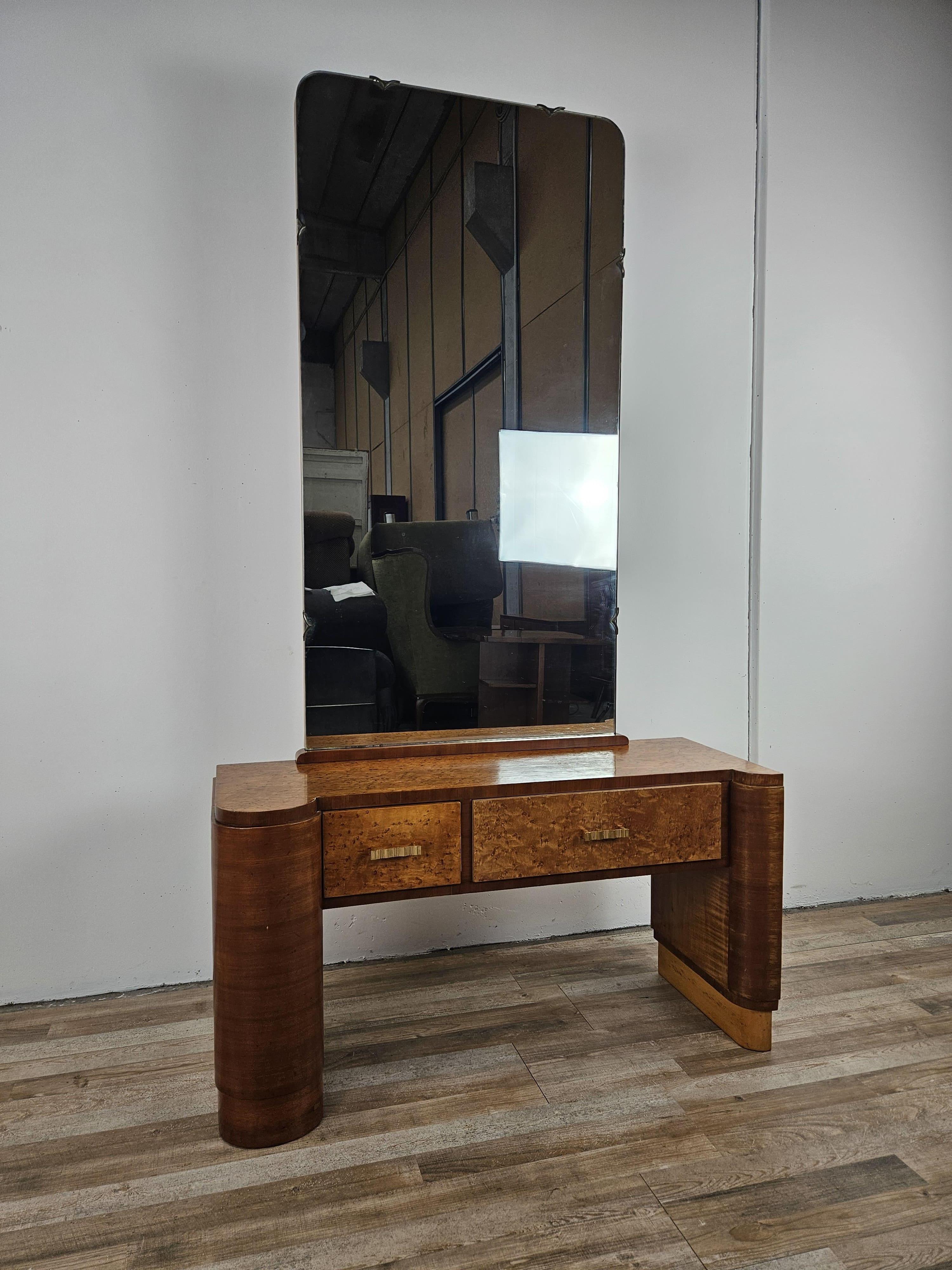 Coiffeuse de maquillage ou d'entrée raffinée en ronce de tuja avec double tiroir large et robuste, enrichie d'un grand miroir en verre original de l'époque.

Le meuble se prête à différents contextes, de l'utilisation classique dans la chambre à