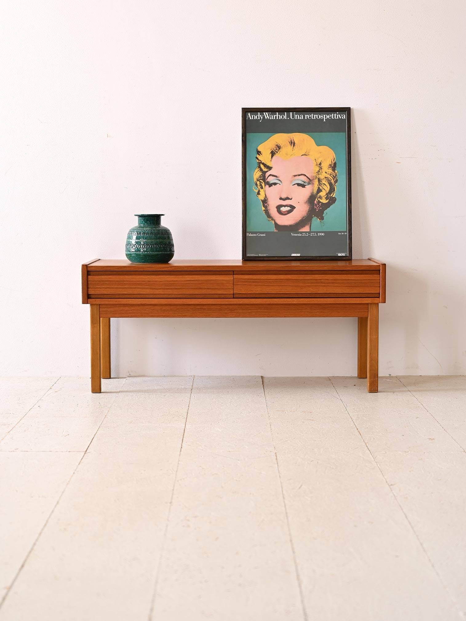 Mueble bajo vintage de teca con dos cajones.

Este mueble bajo de los años 60 en particular es una pieza versátil que puede utilizarse como banco o como soporte de TV. Fabricado en teca de alta calidad, este mueble combina la durabilidad de la