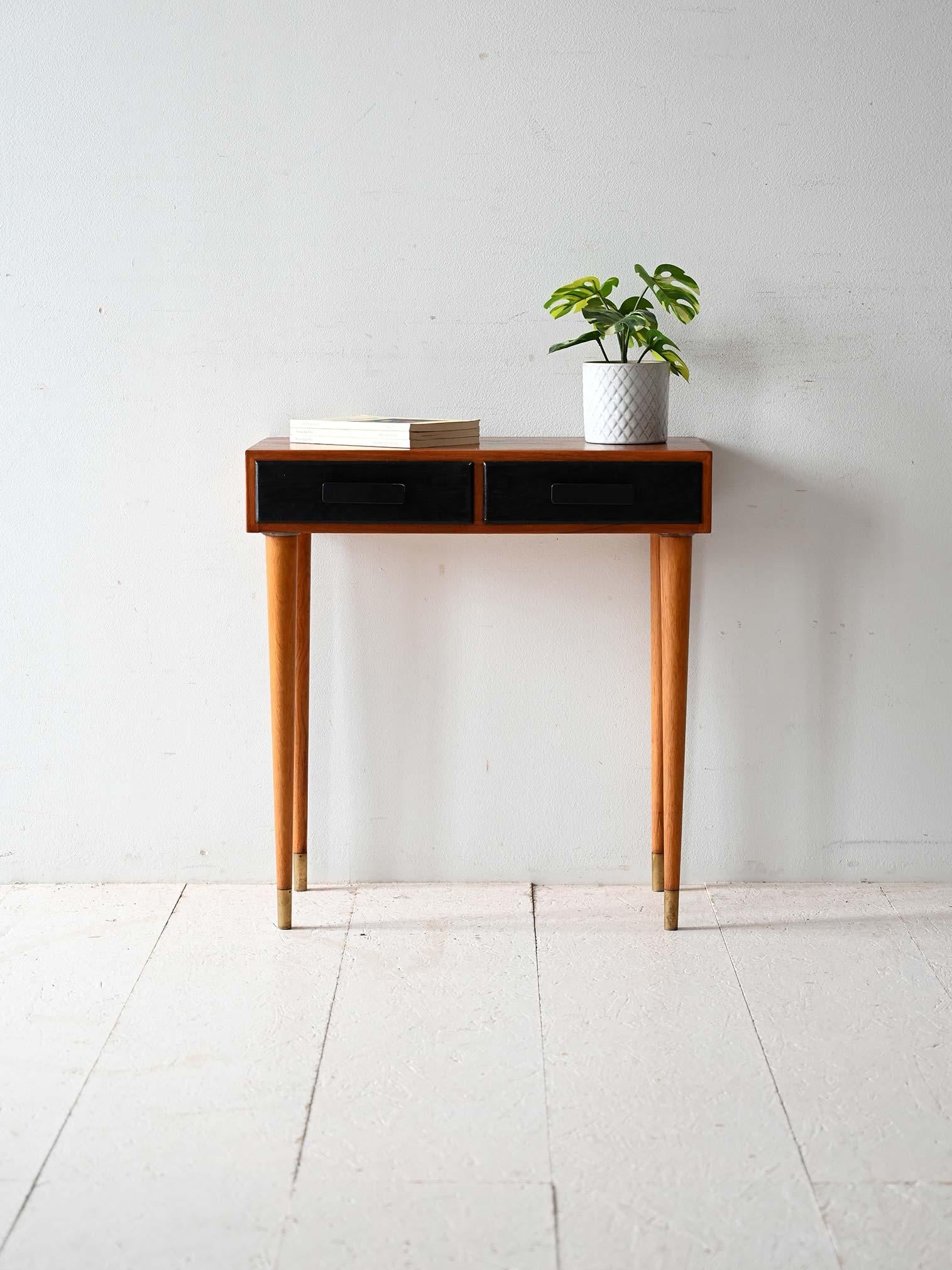 Scandinavian 1960s teak telephone cabinet.

Scandinavian 1960s telephone cabinet with teak frame and turned oak legs, complemented by brass finials. Two front drawers painted black create an elegant textural and color contrast. Originally used in