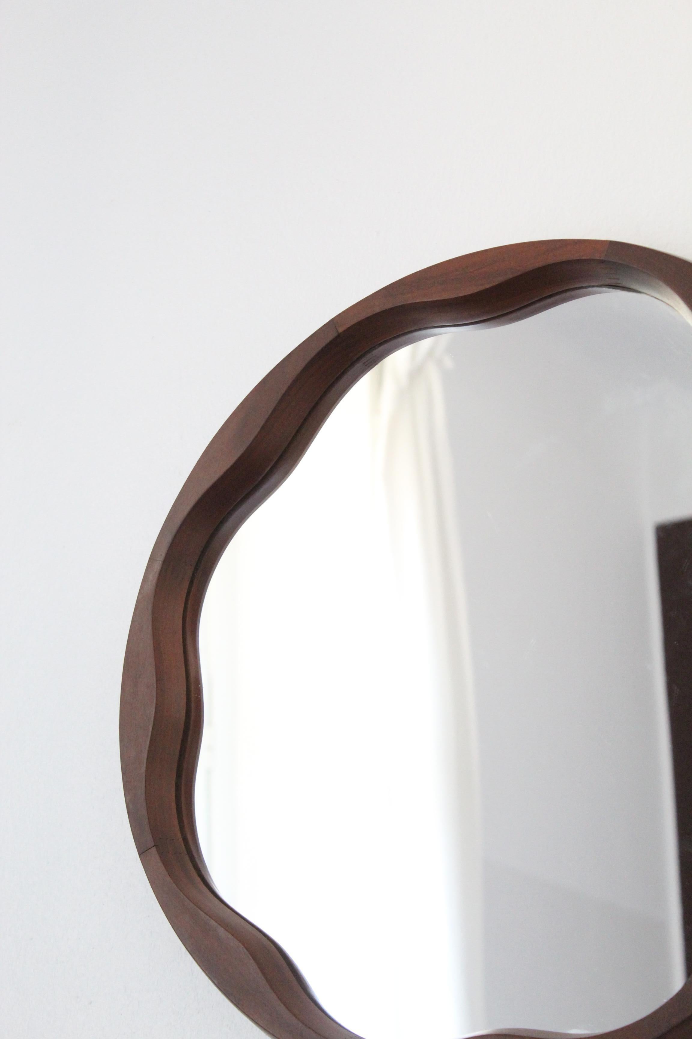 A round organic wall mirror, produced in Italy, 1950s. Cut mirror glass is framed in walnut.

Other designers of the period include Gio Ponti, Fontana Arte, Max Ingrand, Jean Royère, and Josef Frank.