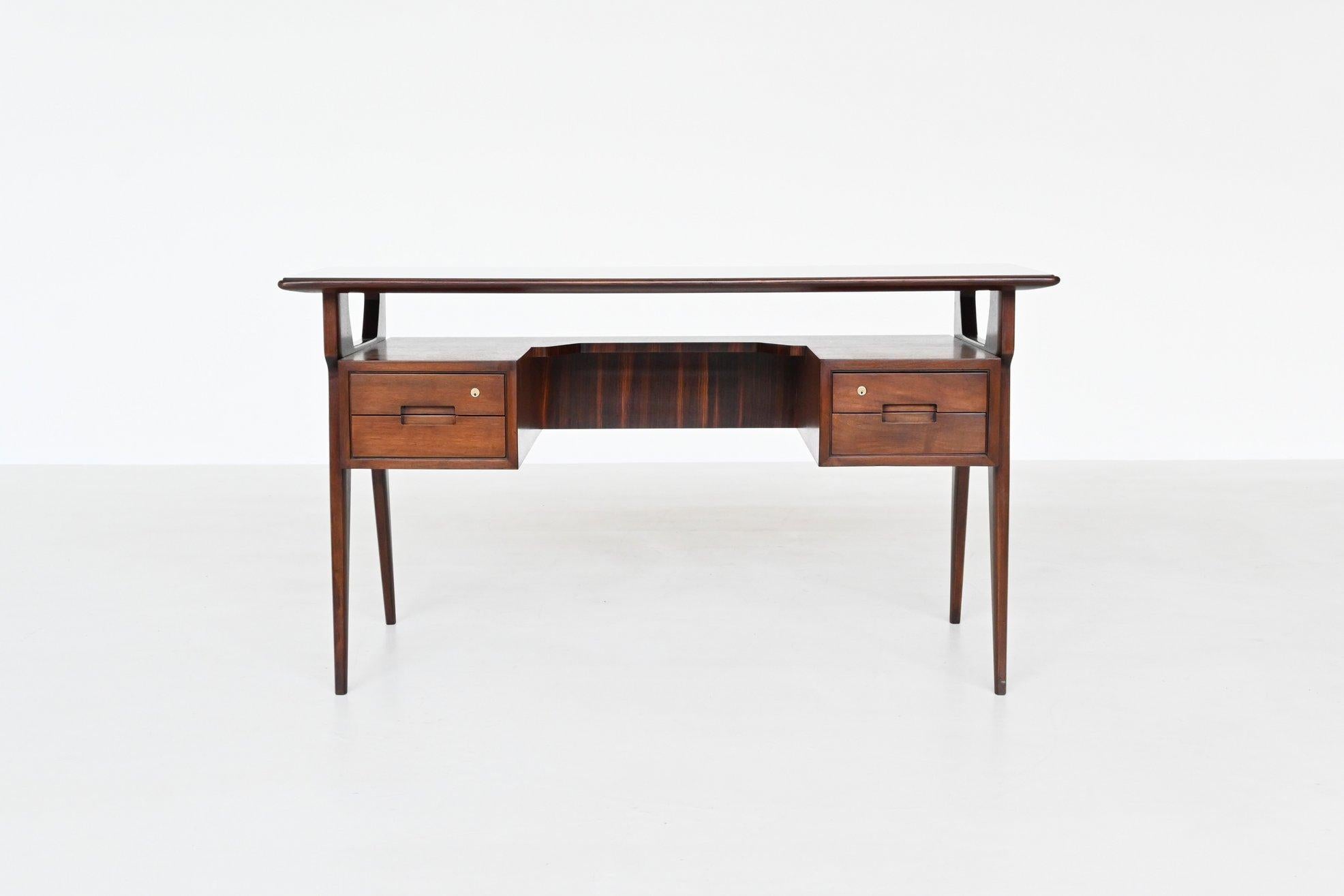 Beautiful elegant shaped writing desk manufactured by Mobili Barovero Torino, Italy 1960. The body is made of nicely grained rosewood and the top is made of inlayed black finished glass. This symmetric boomerang shaped desk has two deep drawers on