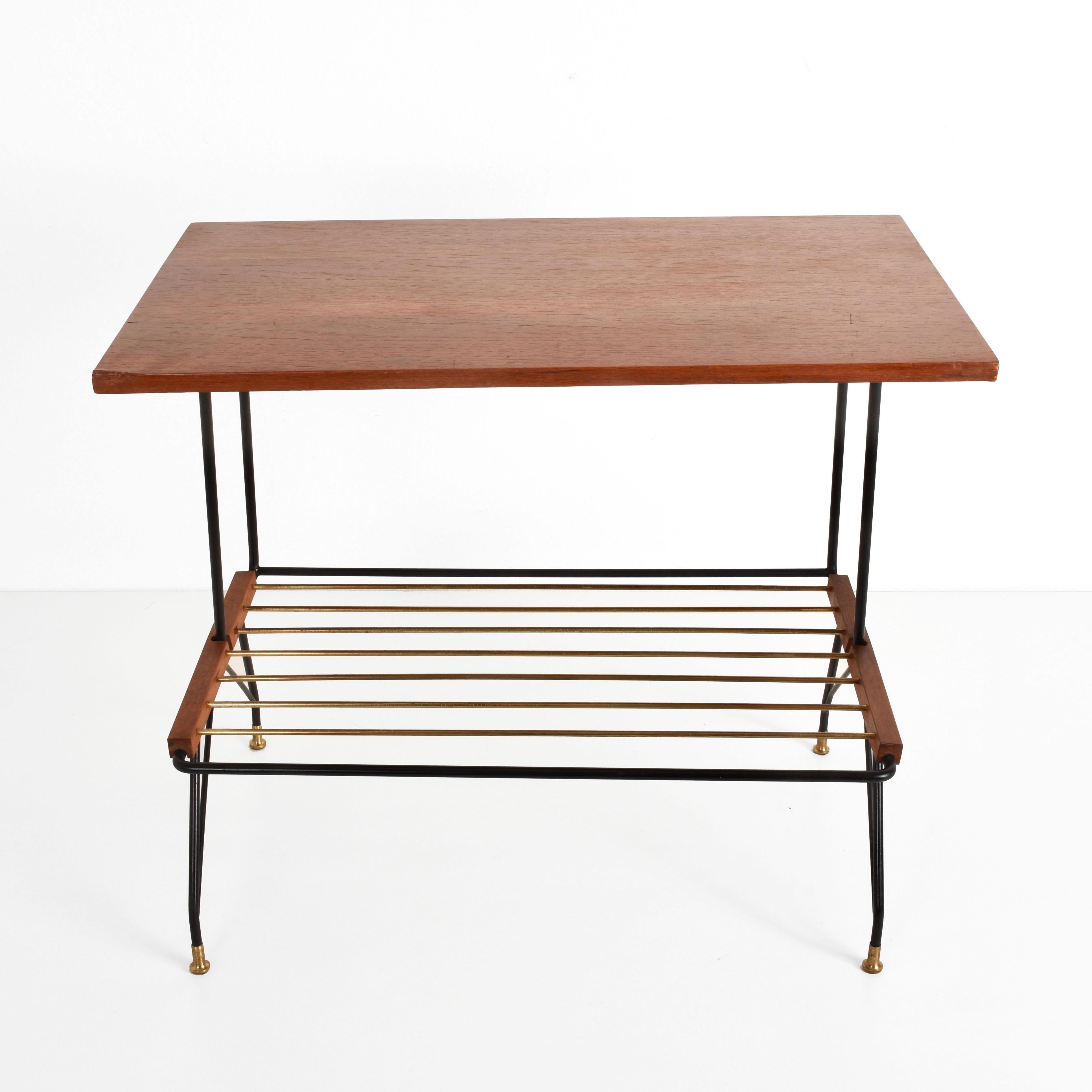 Wonderful midcentury coffee table produced by Mobili Pizzetti Roma. This console table was produced in Italy during 1950s.

It is a rare and elegant wood and black metal end table with a brass magazine rack and marvelous brass feet.

The item is