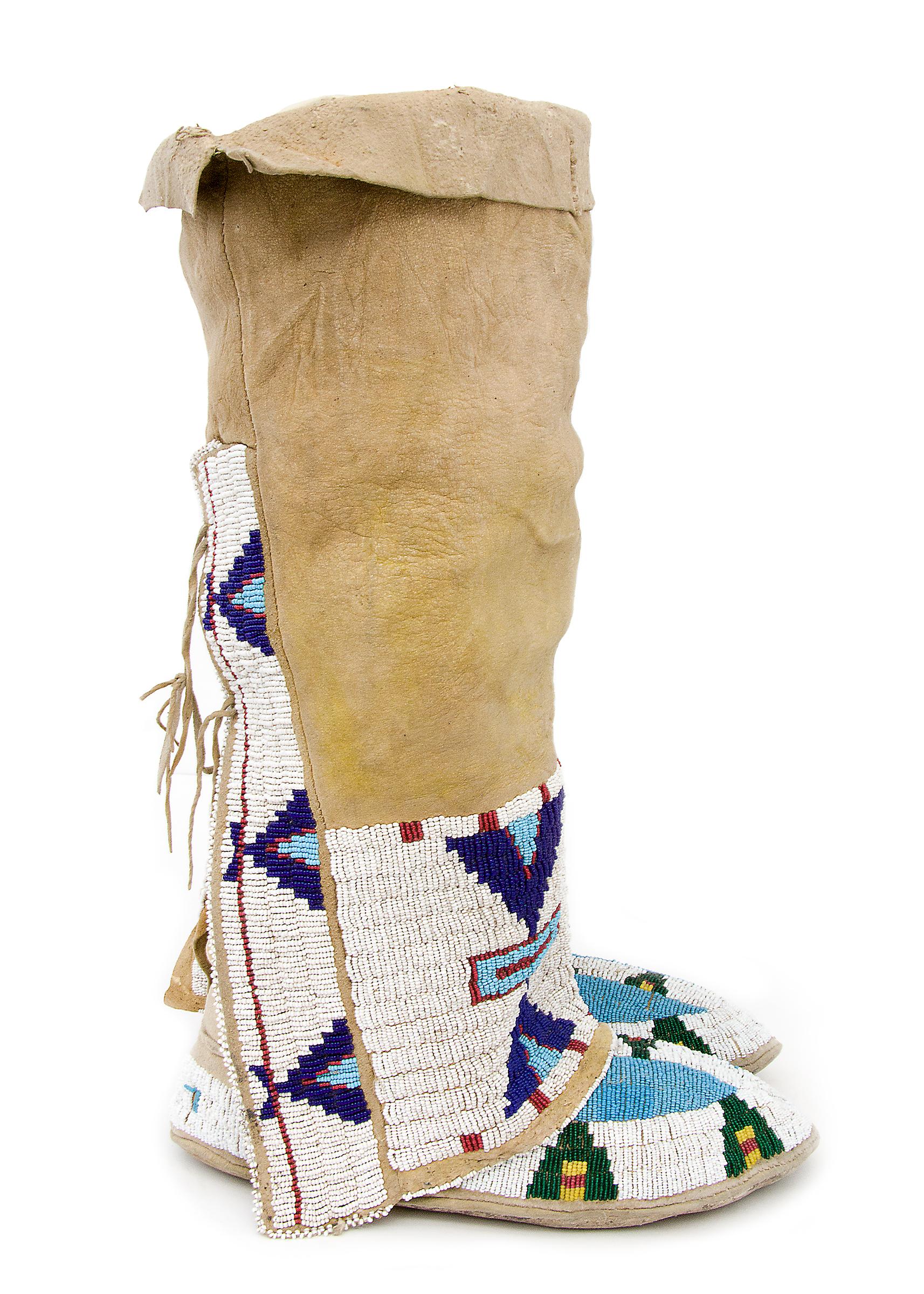 Northern Sioux moccasins and leggings, early 20th century Native American, Plains Indian beadwork. Constructed of native tanned hide with trade beads. Each moccasin has blue buffalo tracks on the vamp and teepee elements in green, yellow and red