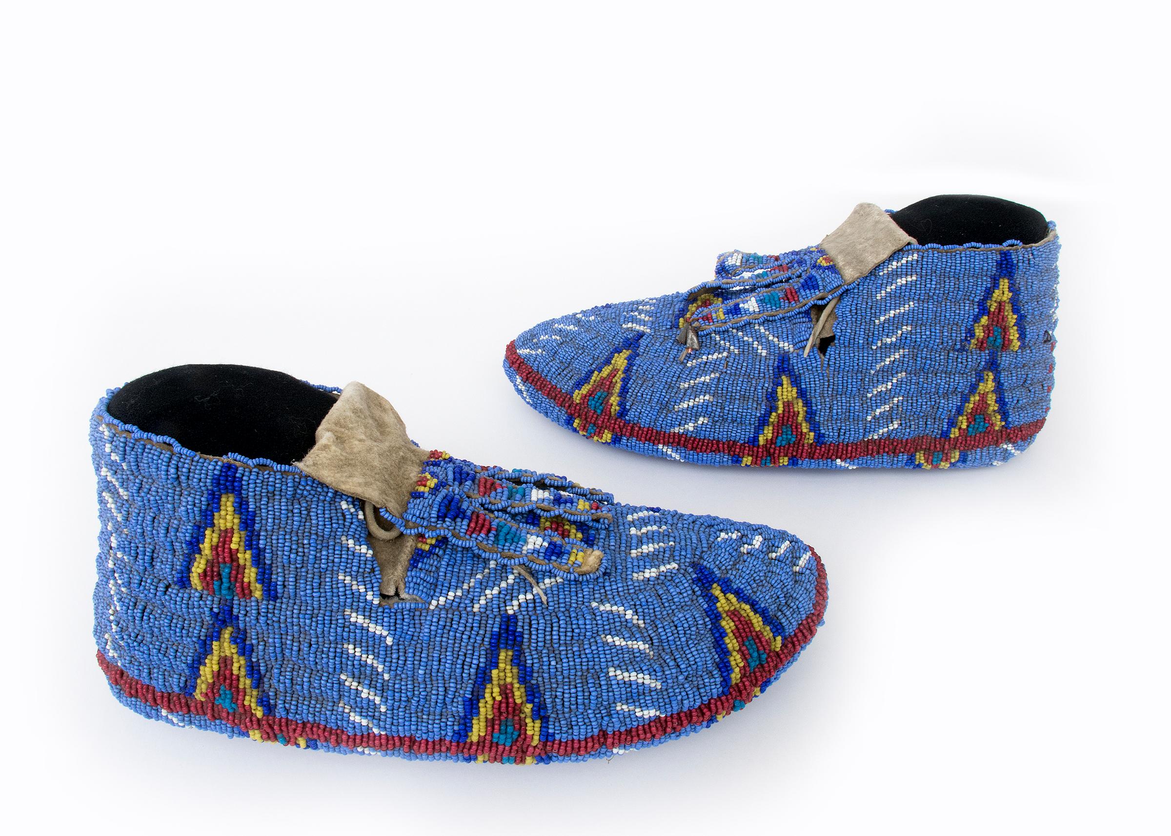 Vintage Native American moccasins, Sioux (Plains Indian) ceremonial style, fully beaded including the soles. Hide, beaded with glass trade beads in colors of blue, red, yellow and white, Pictorial elements include stylized tepee elements against a