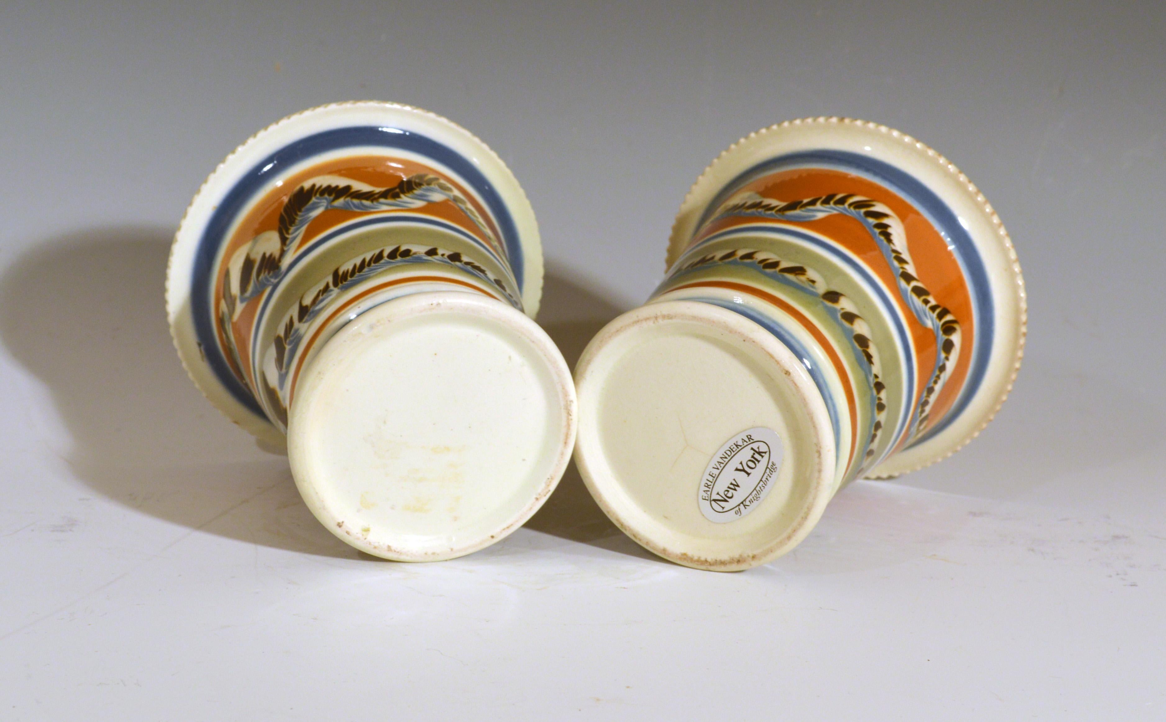 Mocha creamware pottery pair of cachepots with Earthworm design,
circa 1800-1820


The circular cache pots have a flared foot and a flared crimped rim. There are two wide bands around the center with a three-color earthworm design. One a wiggly