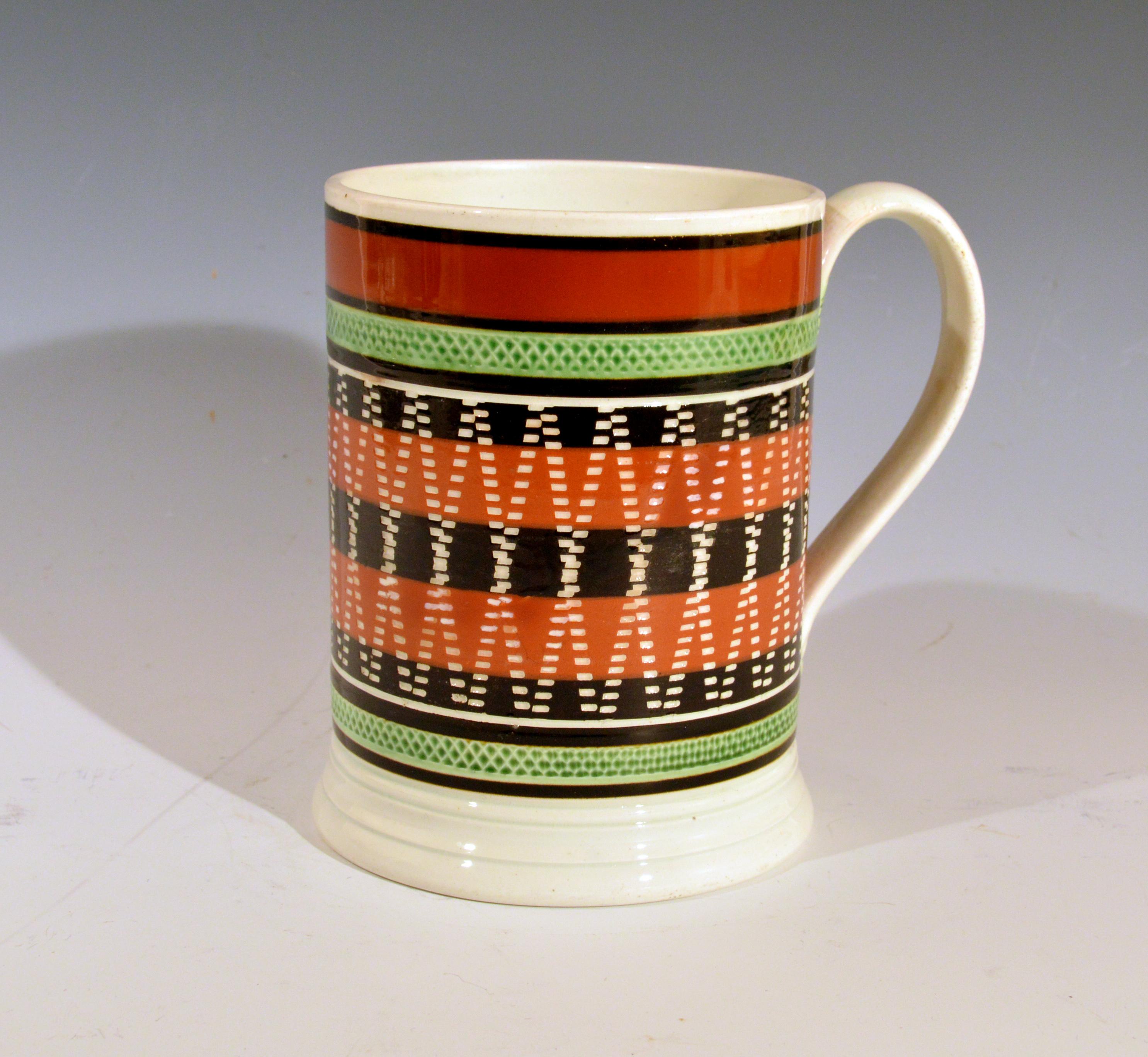 Mocha pottery banded engine-turned Pearlware tankard,
circa 1820 

The unusually decorated engine turned mocha pottery tankard with a series of five bands around the center in brown and ochre with a rouletted band above and below in green. The