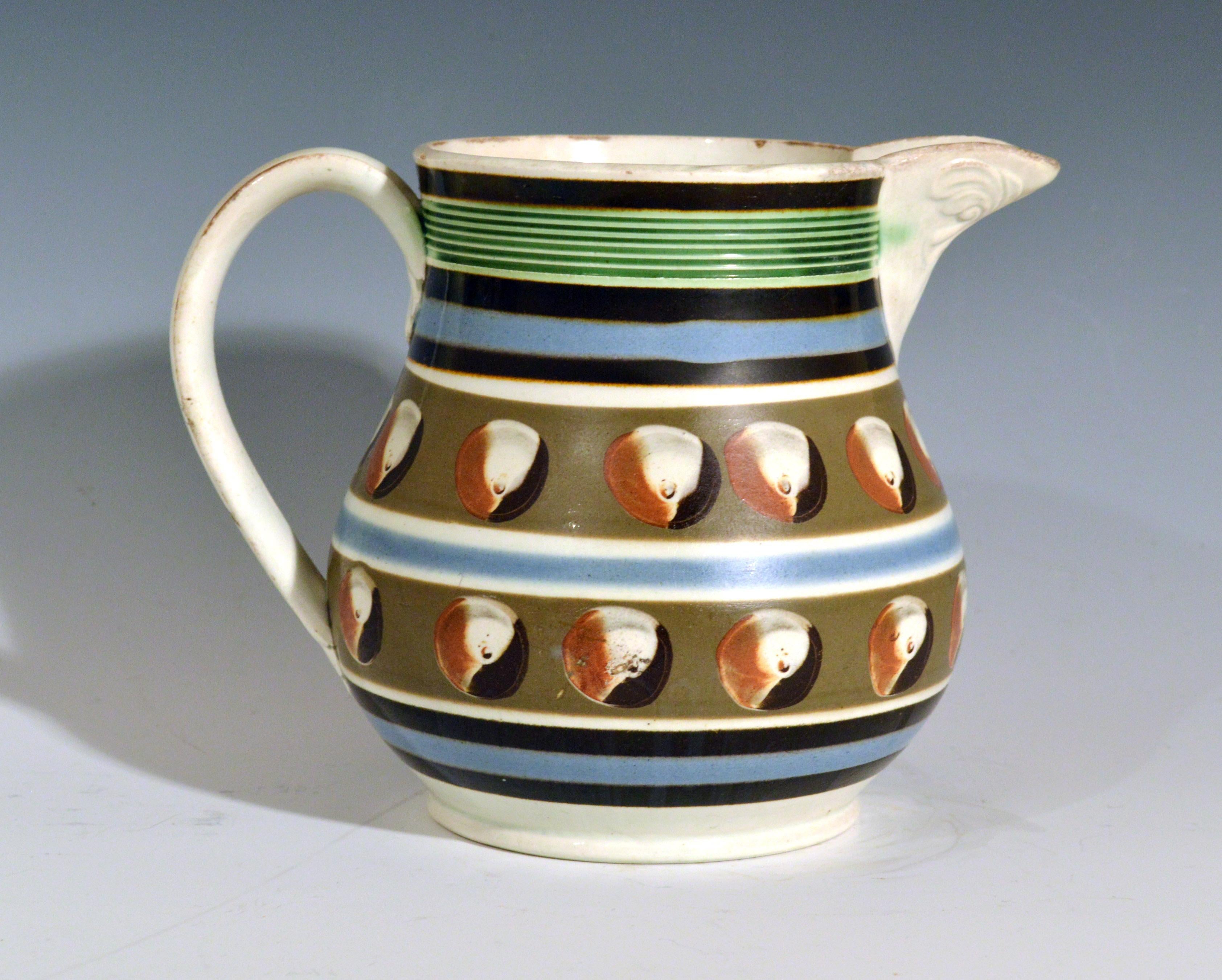 Mocha Pottery double cat's eye-decorated jug,
circa 1820

The jug with two bands of a gray-brown ground each with a series of four-color cat's eye-red, brown, white and gray. Three bands of brown and blue above and below and a blue band with