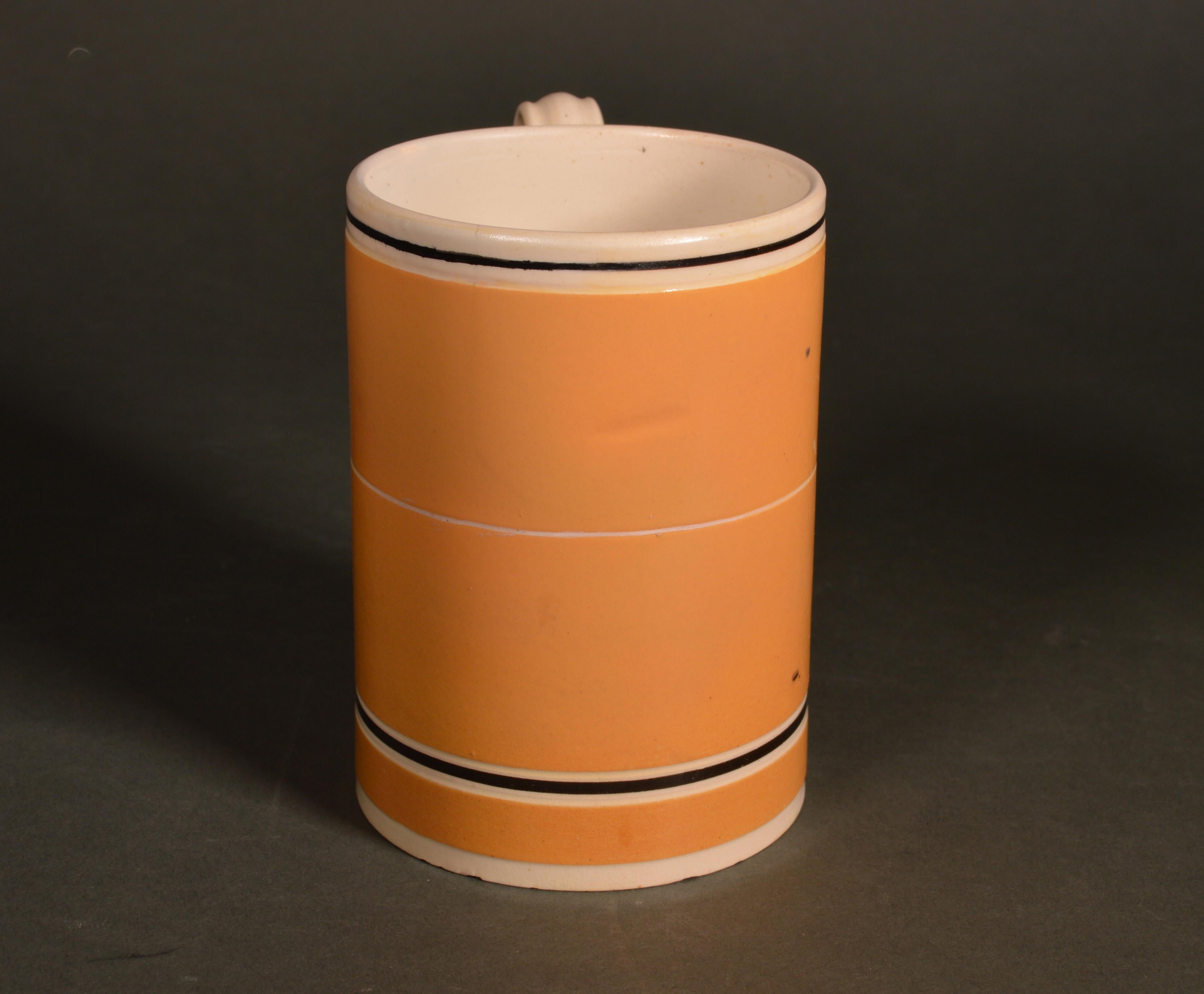 Mocha pottery mug with ochre slip ground,
circa 1790-1810
  

The cylindrical mug with a flared foot has an ochre-colored slip ground with a wide white band at the rim with a narrow brown line encircling the body. Another narrower white band is