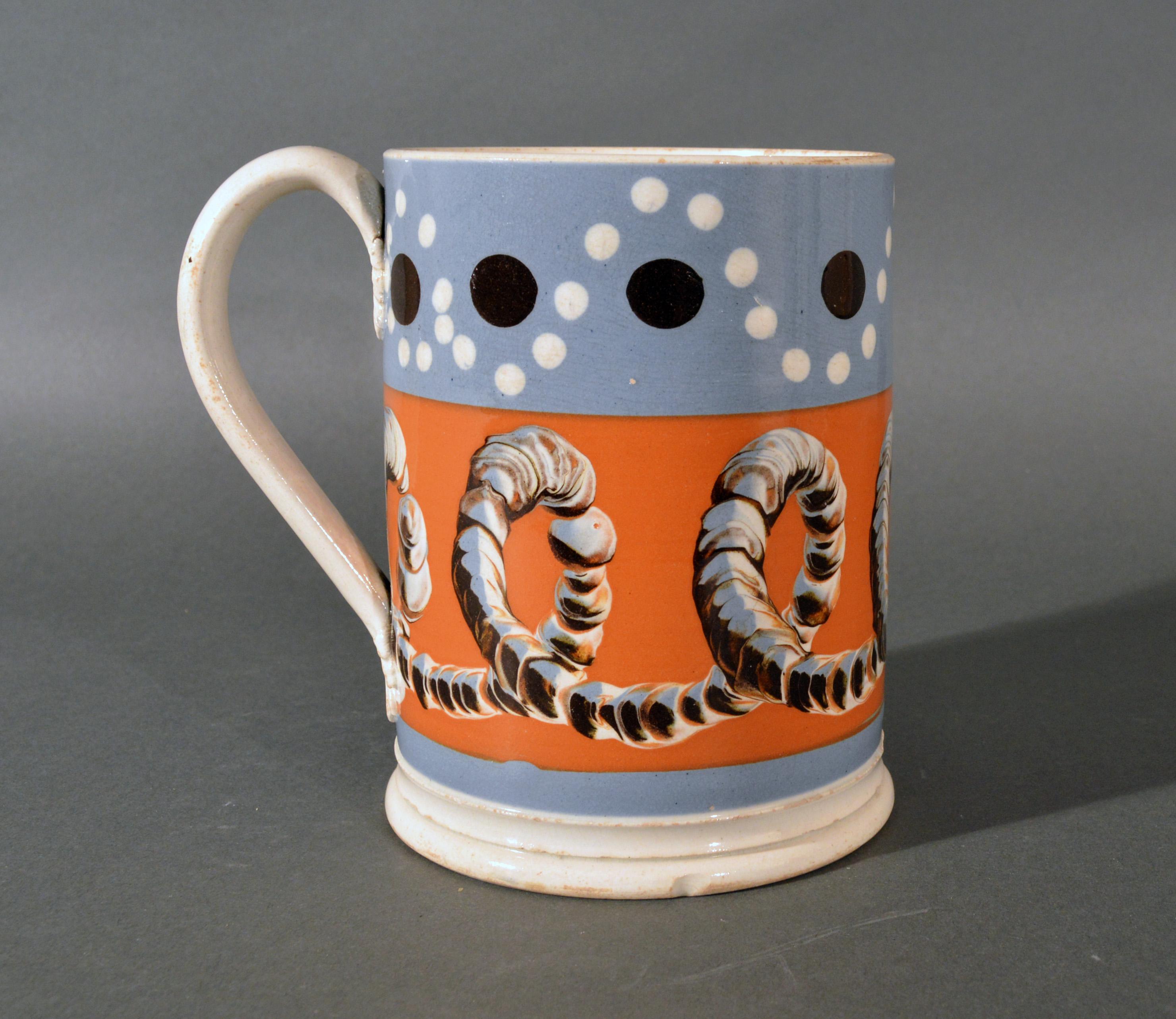 Mocha Tankard with earthworm and dot decoration,
early 19th century
(Ref: NY9366-npim)

Fabulous large tankard or mug decorated with slip bands in an unusual light blue and ochre. The central ochre band with a three-color earthworm design while