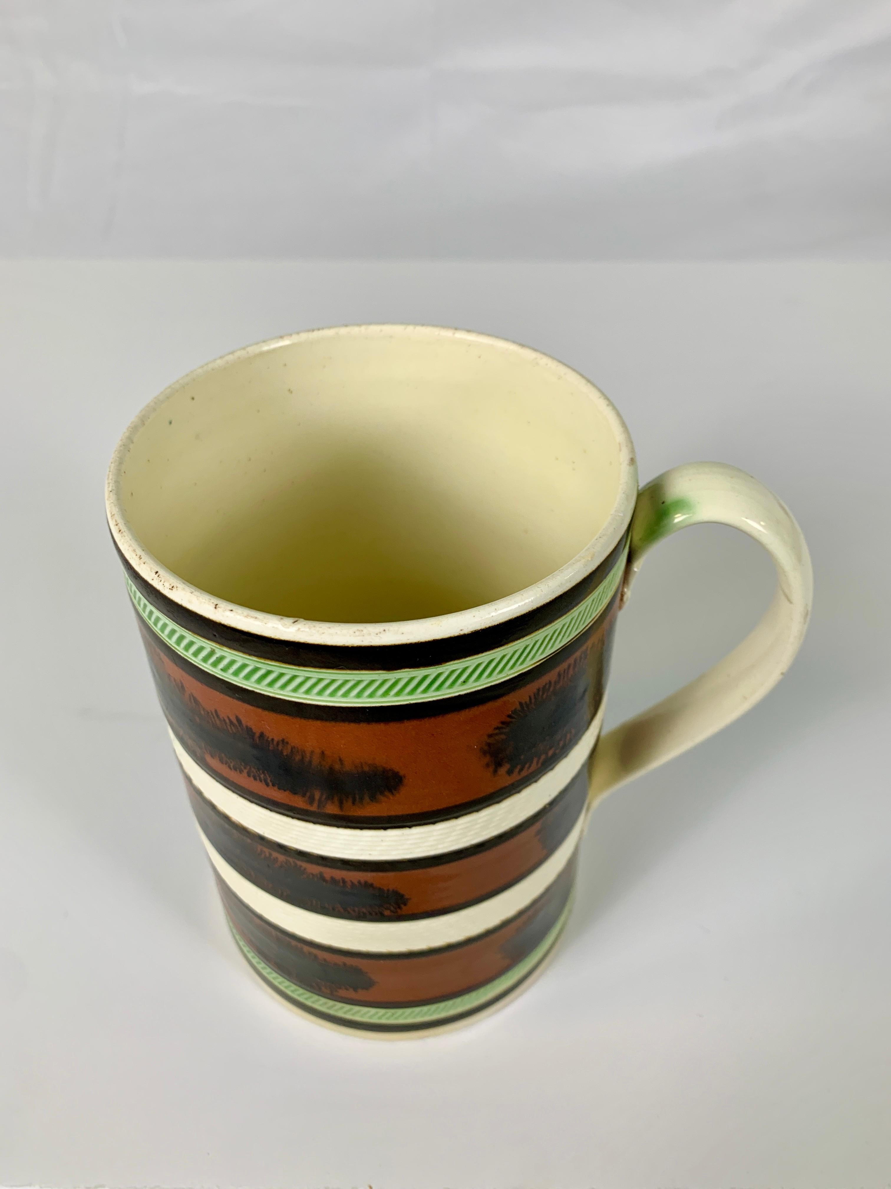 Made in England circa 1800, this exquisite mug is decorated with three milk chocolate-colored slip bands, each band with midnight brown 
