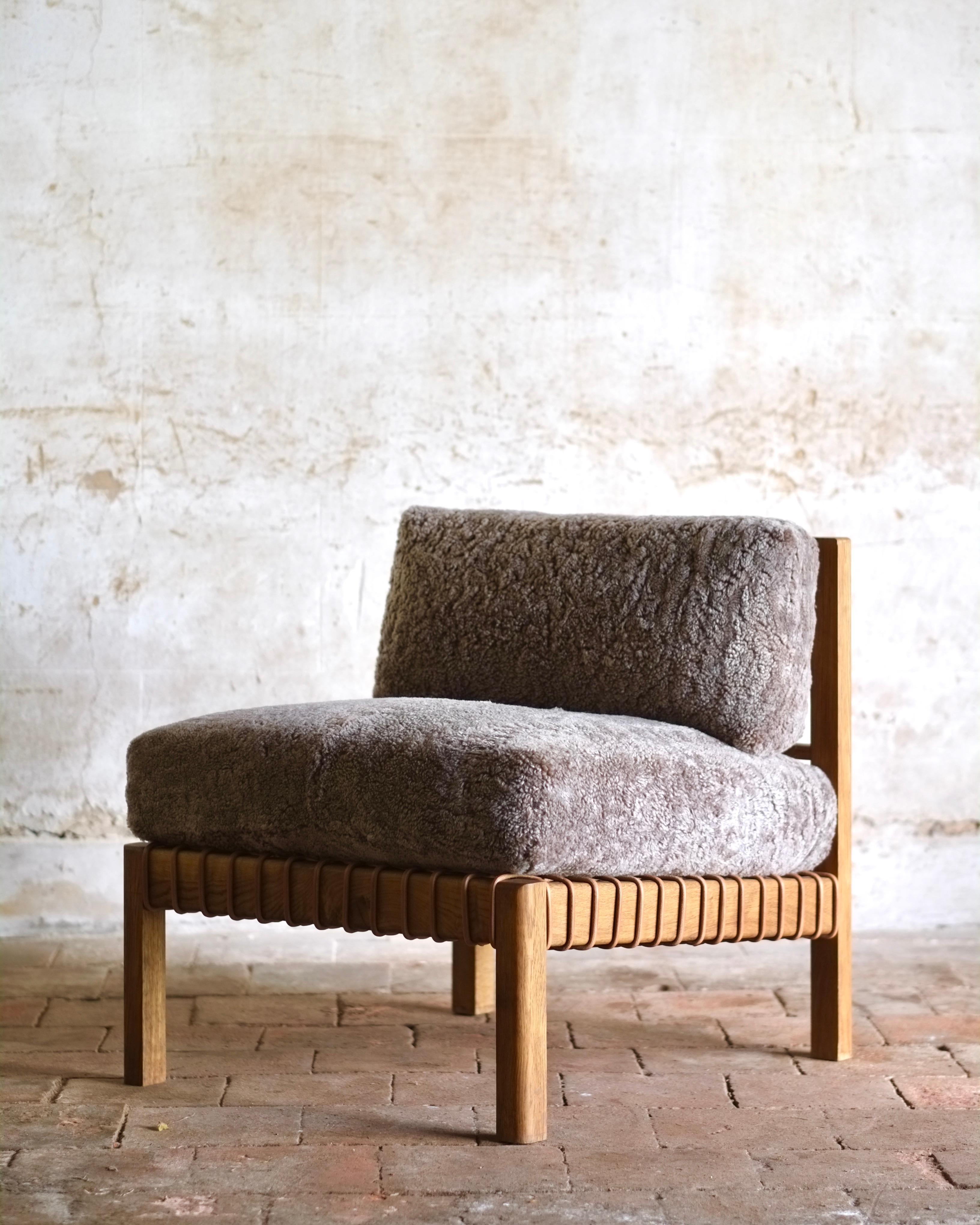The Mochi uses three types of leatherwork to create a simple but beautifully detailed piece; woven leather cord webbing supports the supple upholstered cushions. Large shearling panels are wrapped whole around the interior to give a seamless
