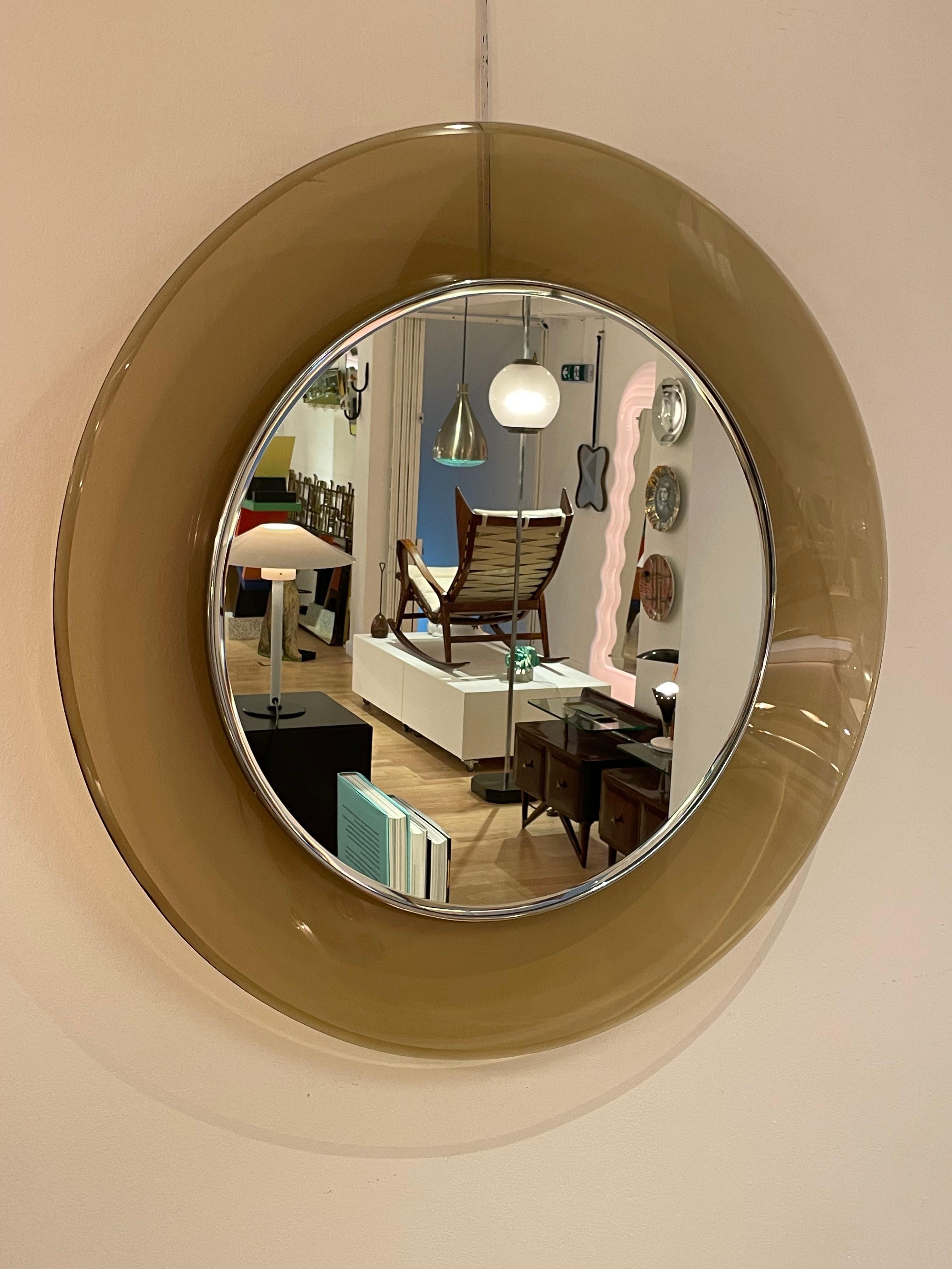 Un espejo de cristal cóncavo Mod. 1669 de cristal cóncavo circular, diseñado por Max Ingrand para la empresa milanesa Fontana Arte, hacia 1960. Este bello ejemplar de cristal de color marrón claro/amarillo oscuro tiene un marco de latón cromado con