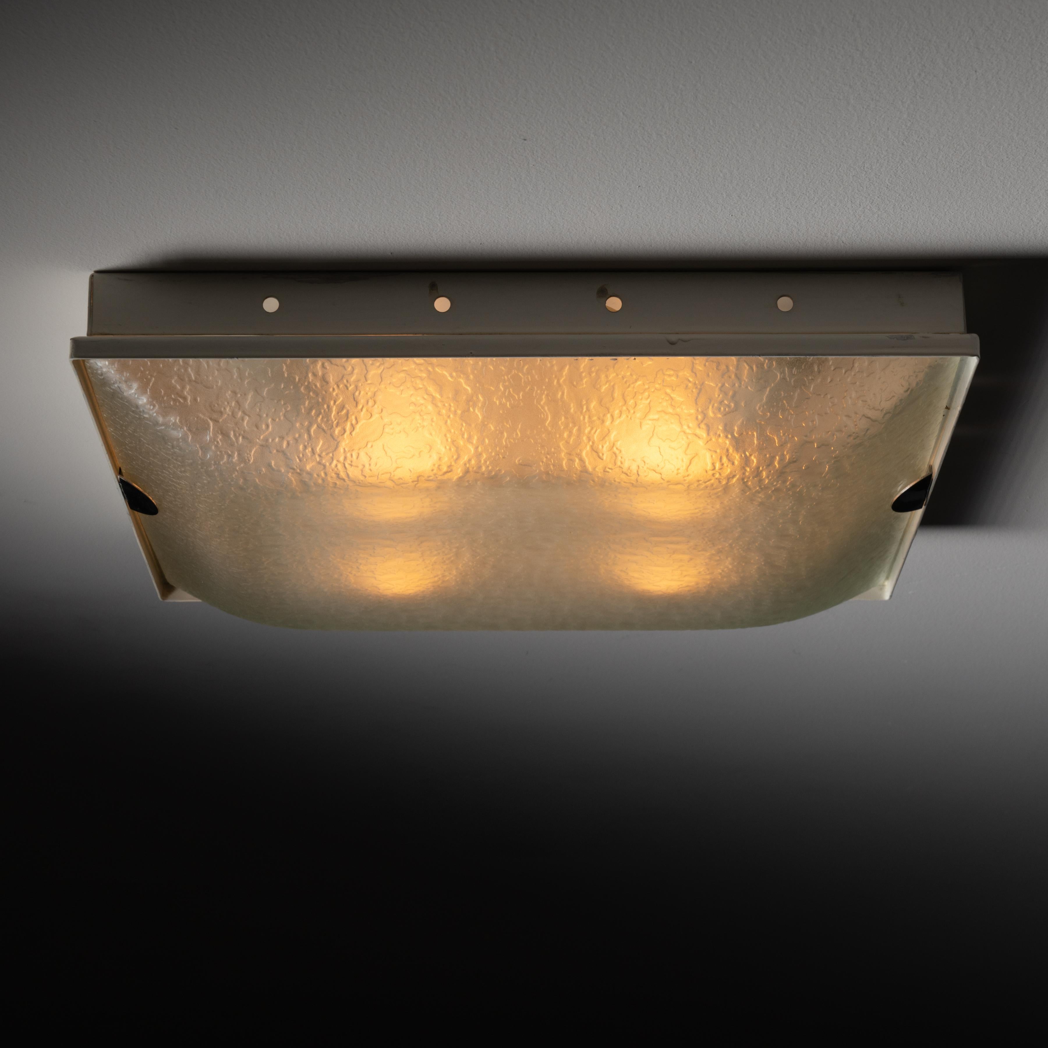 Model 1940 wall or ceiling light by Max Ingrand for Fontana Arte. Designed and manufactured in Italy, circa 1960. Simple square-shaped flush mount with textured glass shade and enameled brass frame. This flush mount holds four E14 sockets, adapted