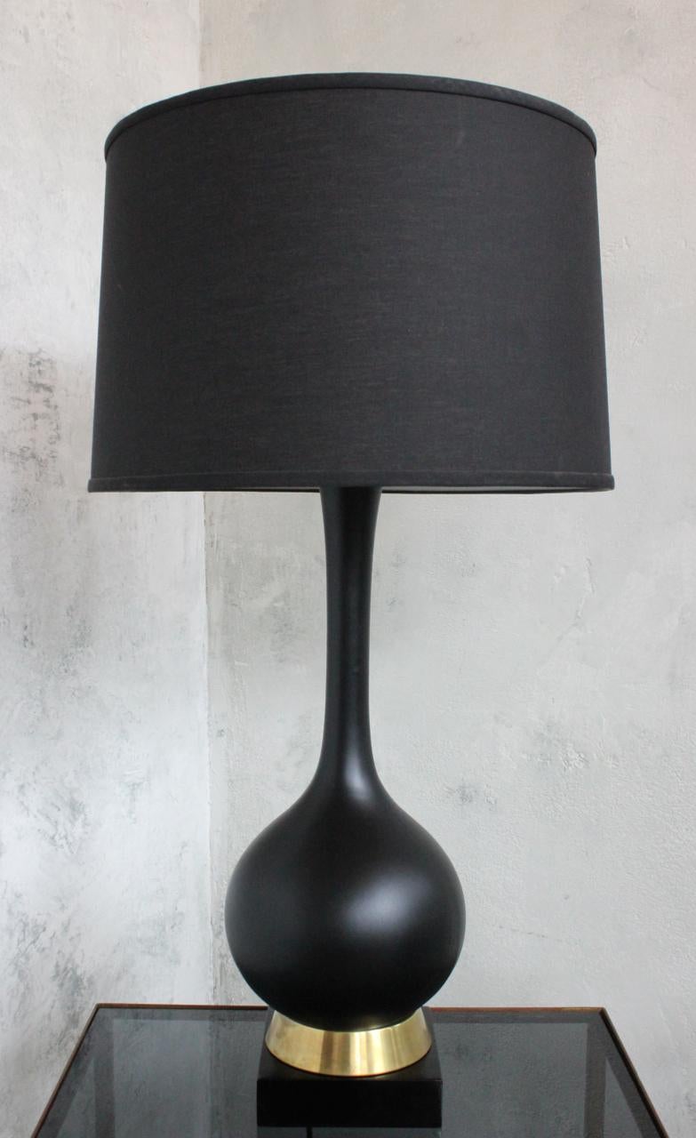 An American 1960s black ceramic table lamp on a brass and wood base. This modern mid century black ceramic table lamp is a striking and unique piece of vintage lighting. The combination of the black ceramic body with the brass and wood base gives