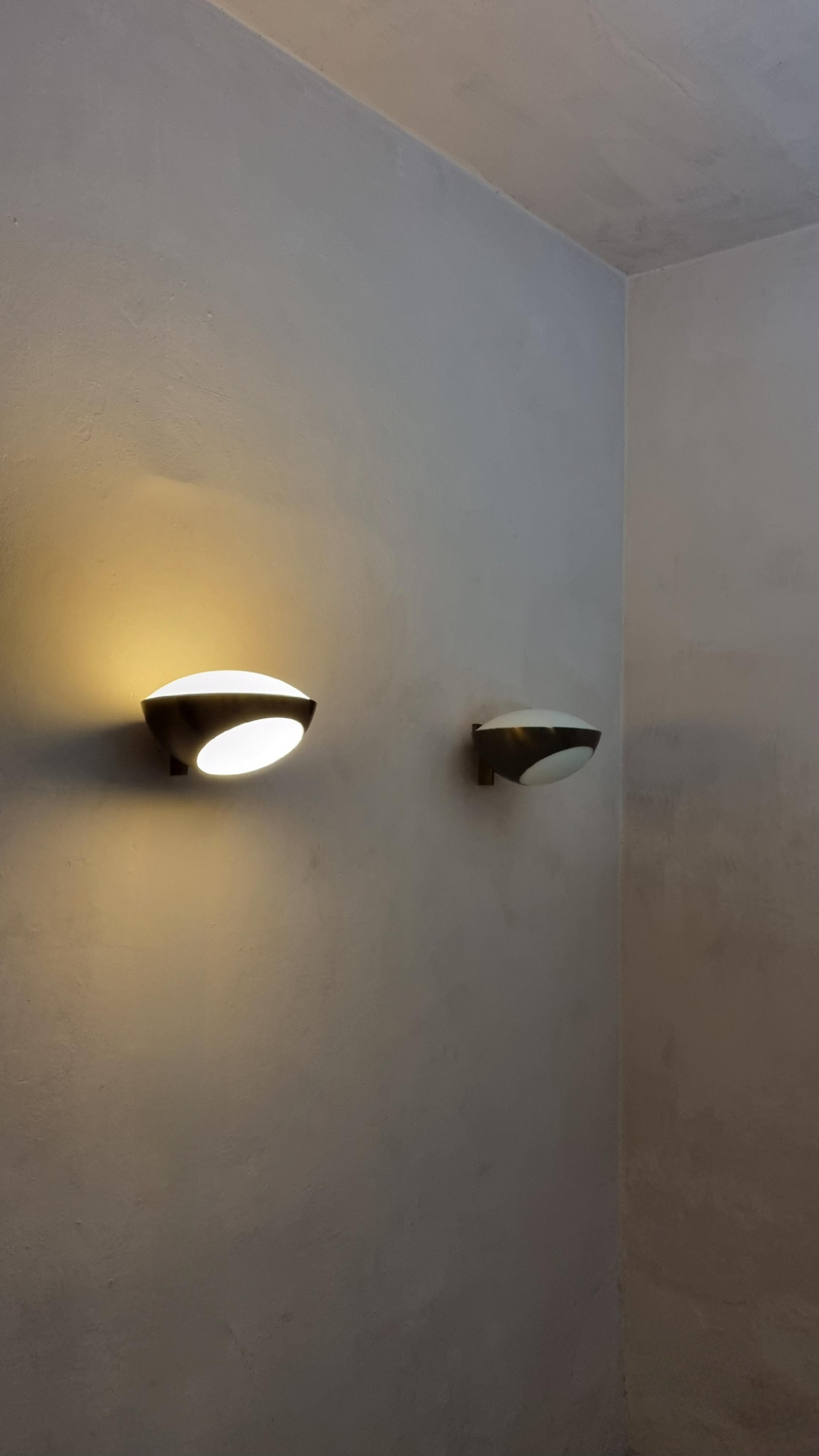 Iconiche lampade a parete Mod. 1963 disegnate da Max Ingrand per Fontana Arte nel 1960.
Struttura in ottone, vetro satinato bianco, eccellenti condizioni, prima produzione.

Celebre maestro del vetro d’arte, Max Ingrand cresce ammirando le vetrate