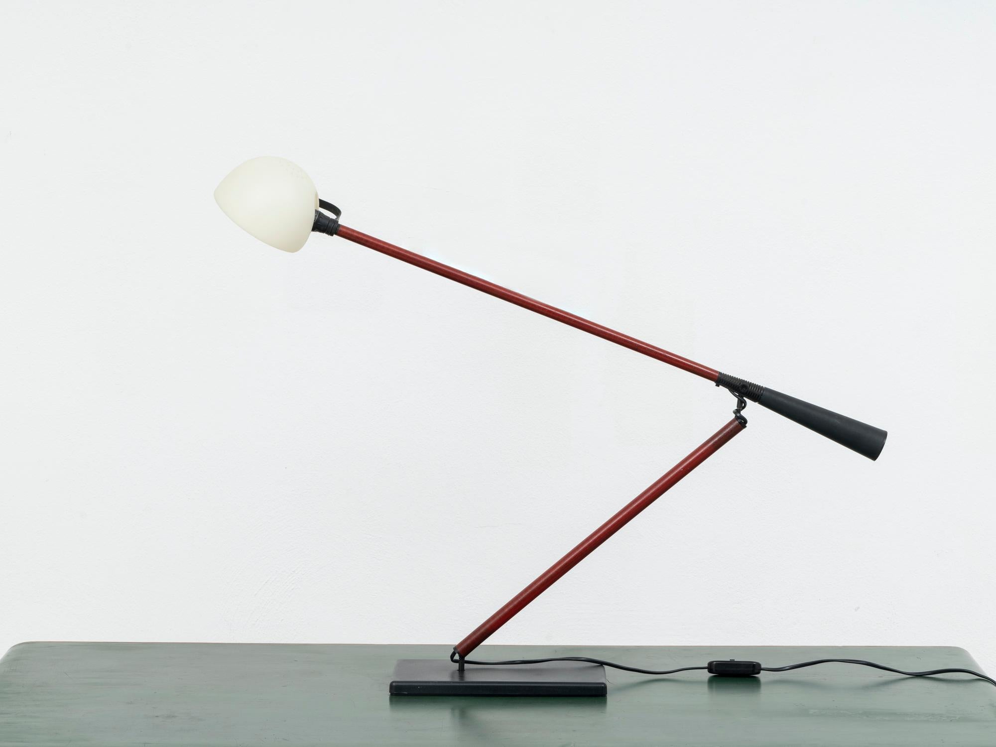 This lamp was designed by Italian architect and designer Paolo Rizzatto in 1975, and was his second project, the table version of the 265 wall lamp. This lamp was conceived to cover the whole area of any desk and to be extremely light (therefore the