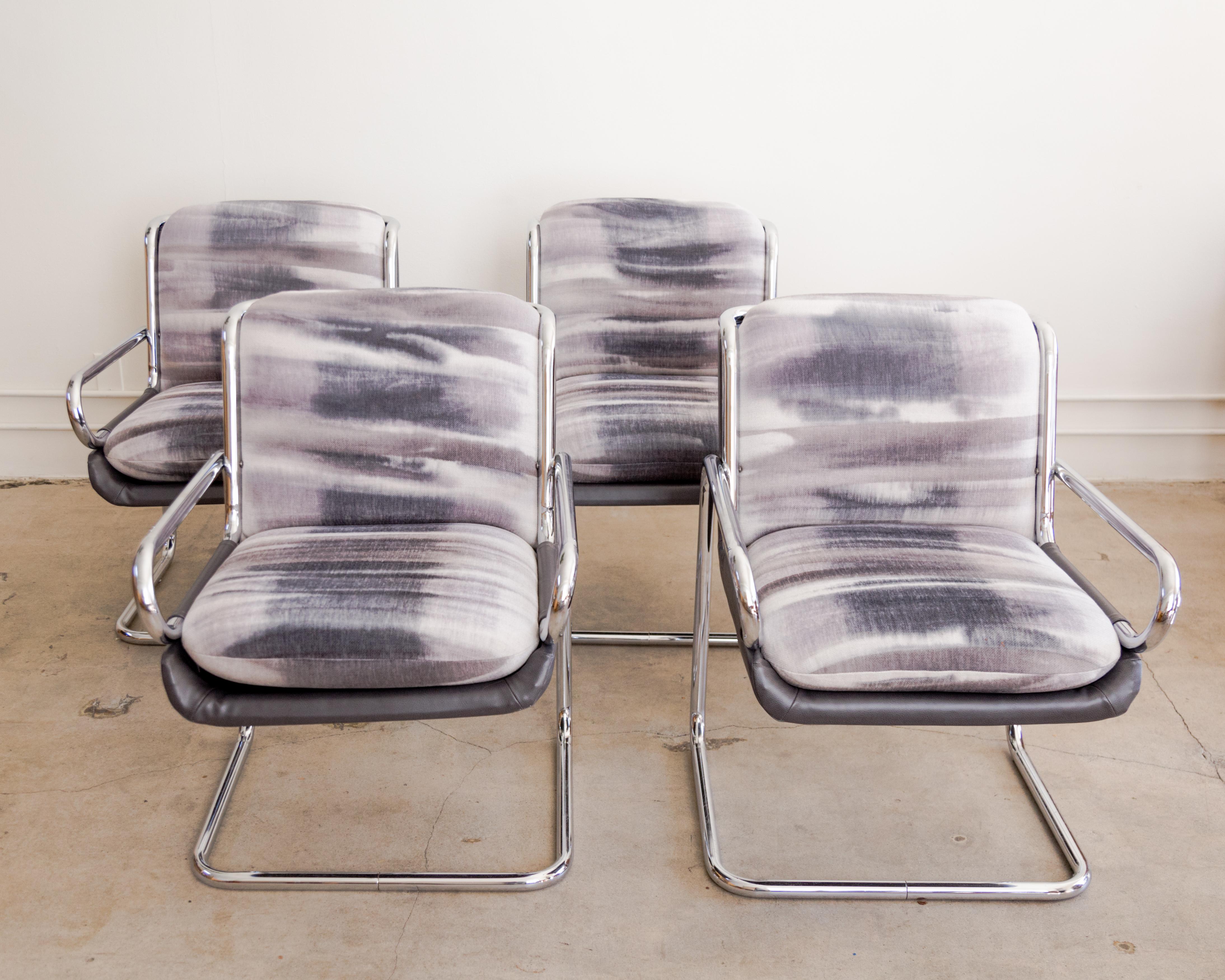 Set of four mod cantilevered dining armchairs with polished chrome frame, newly upholstered resist dye cushions and vegan leather shell, USA circa 1980's.