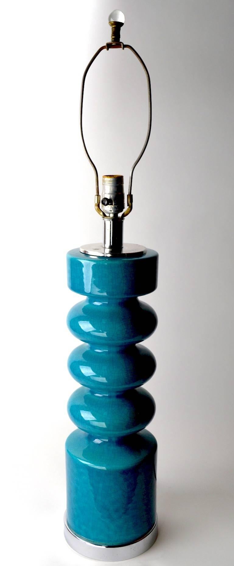 Cool Mod form turquoise table lamp. This lamp is in clean, original, and working condition, showing some wear to the chrome disk fitment at the top, as shown. Height to top of ceramic 19.25 inch x 33.5 inch total Height, shade not included.