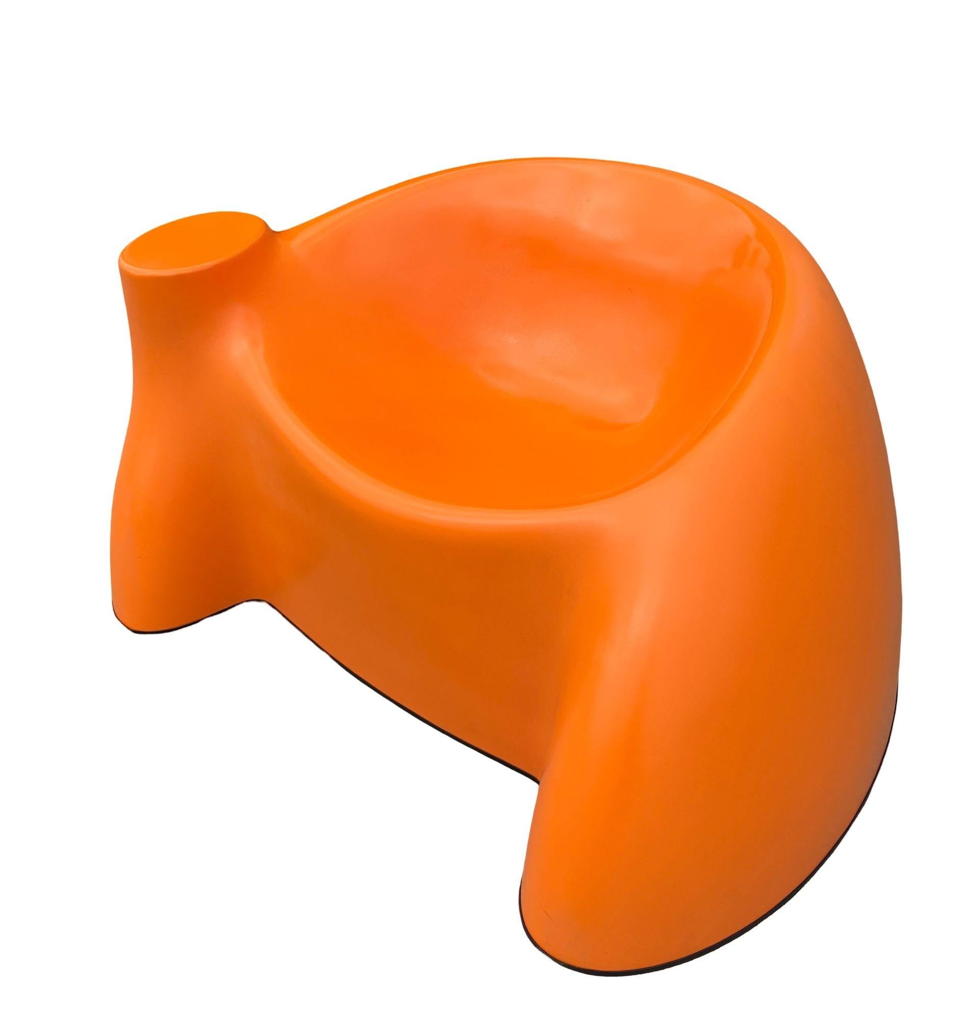 This vintage lounge chair from the 1970s draws inspiration from Wendell Castle's iconic castle chair, showcasing his mastery of organic, sculptural design. Crafted in vibrant orange reinforced fiberglass, it embodies both playfulness and