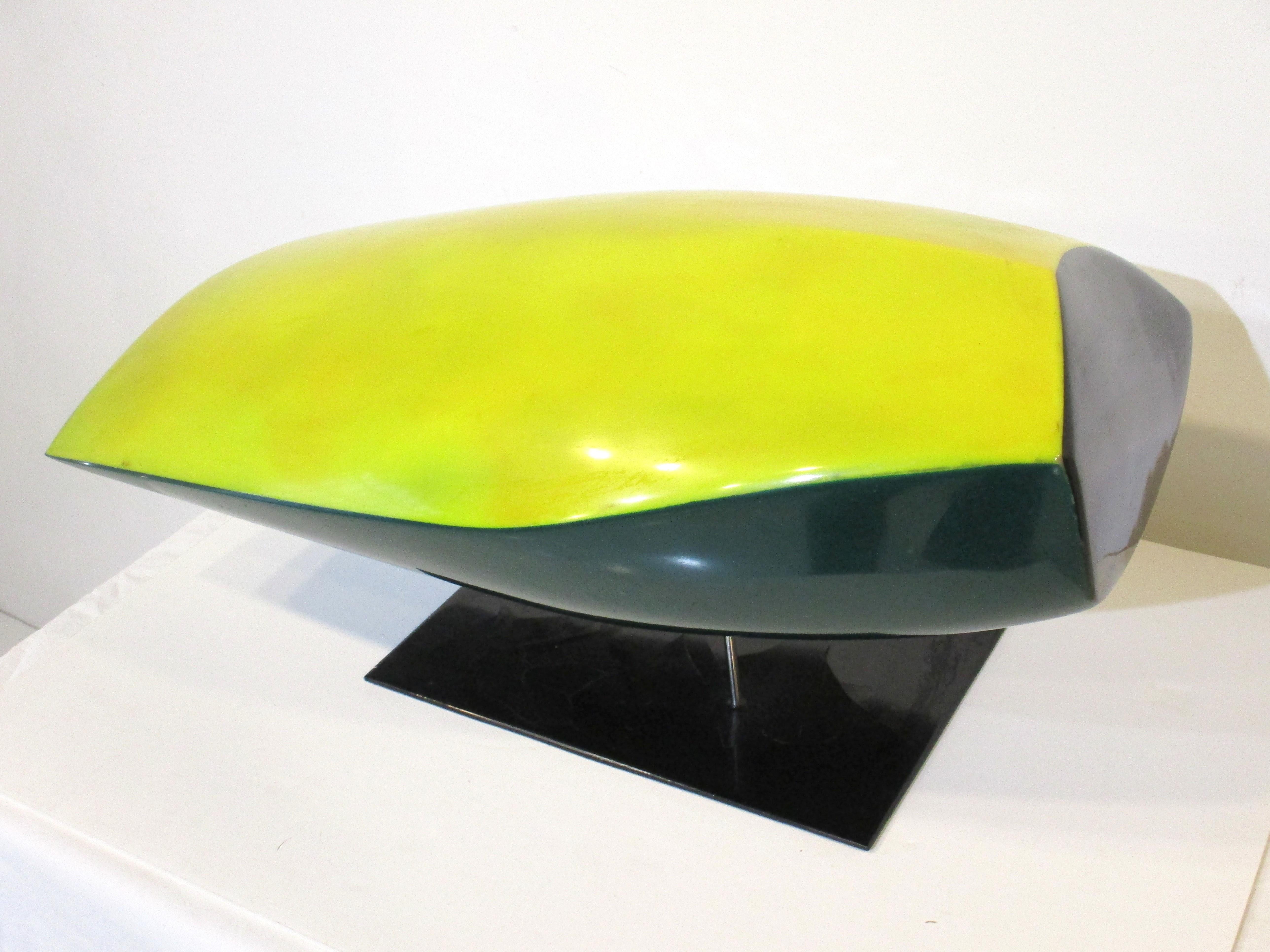 A fiberglass and molded color formed Mod sculpture in yellow and dark green black tones. Mounted on a chromed steel staff and attached to a steel base covered in black fiberglass giving the piece a floating affect. Created by artist Lawrence Glasson