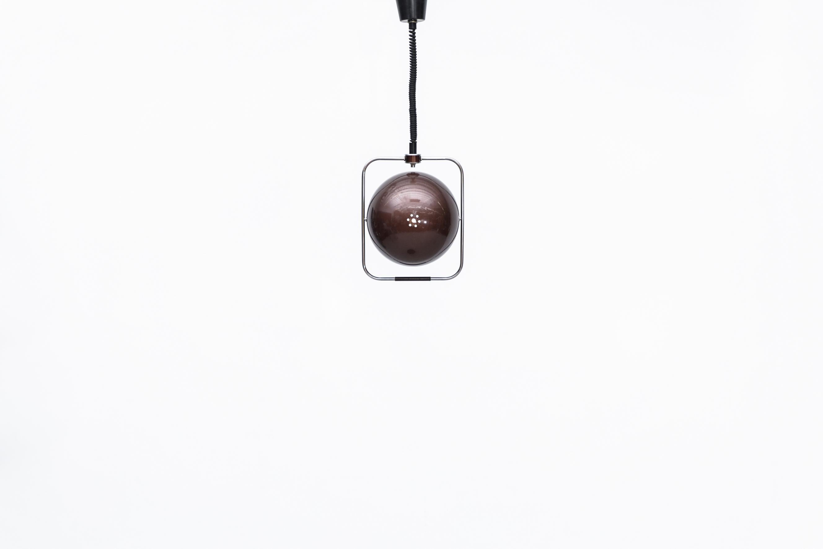 Midcentury Gepo pendant lamp with maroon metallic enameled globe sitting in square chrome frame. The canopy houses a pulley allowing the telephone cord-like wire to extend and retract as needed. The chrome frame has a built in handle for height