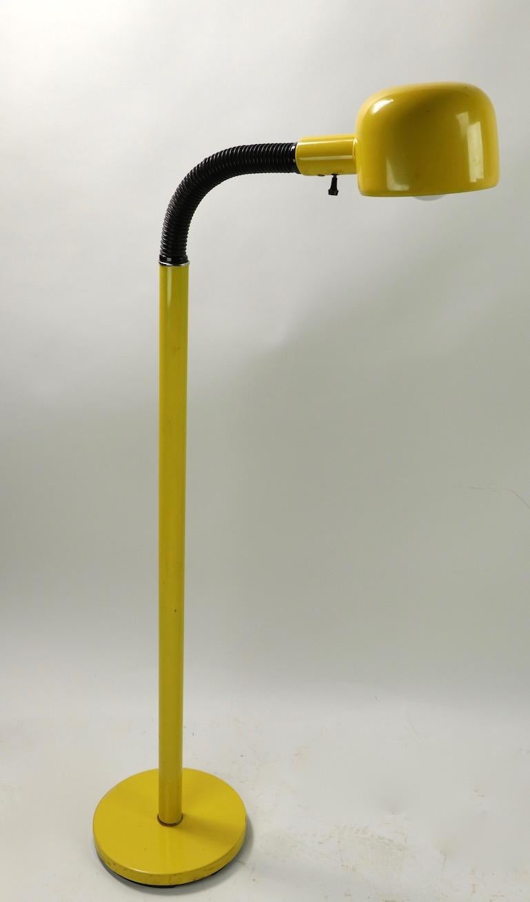 Mod gooseneck floor lamp with yellow metal base, shaft and hood shade, the arm section is black flex plastic hose. The hood shade is 5.5 inch diameter x base 10 inch diameter x projection when perpendicular 16 inch. Flex section is adjustable to