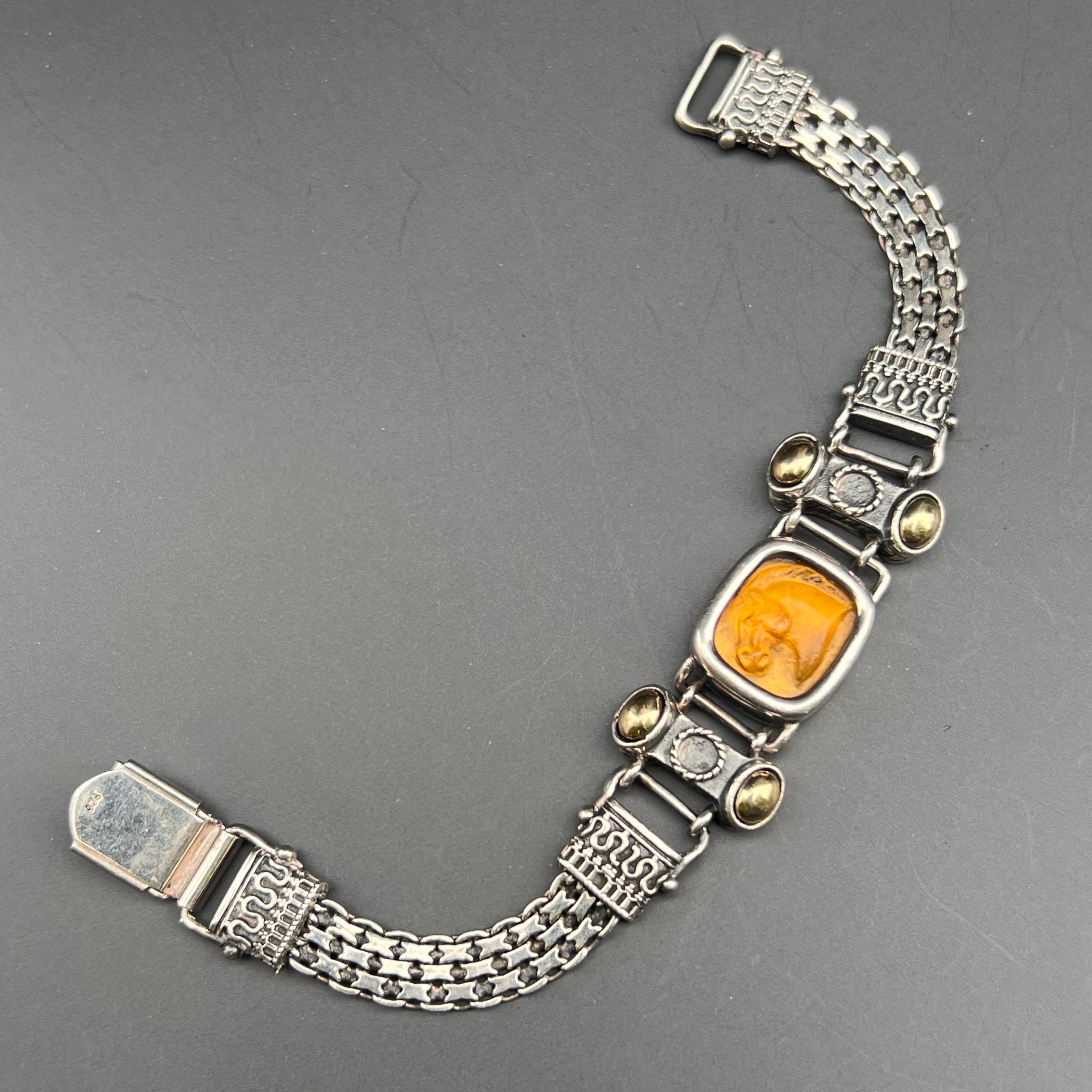 This exquisite Unsigned designer bangle features a striking molded citrine glass horse head set in sterling silver and 14kt gold accents . The woven matte body adds a unique texture, and the folding clasp ensures a secure fit. Dating to the late