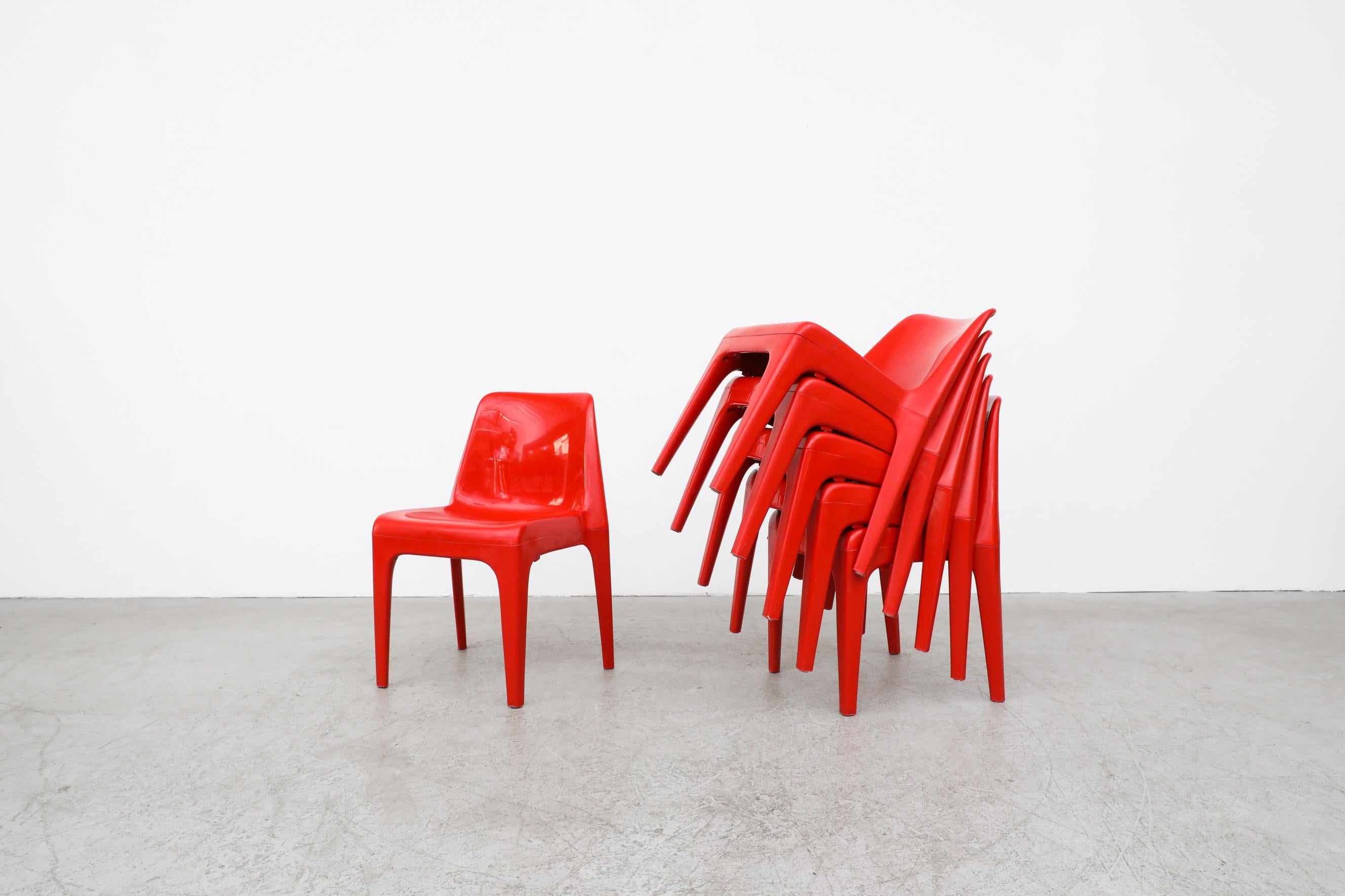 Fire engine red acrylic stacking chairs in the style of Kartell 4850 by Castiglioni, made and stamped by Schröder & Henzelmann. They offer a sleek and colorful addition to any room or patio. In original condition with a few minor scratches and no