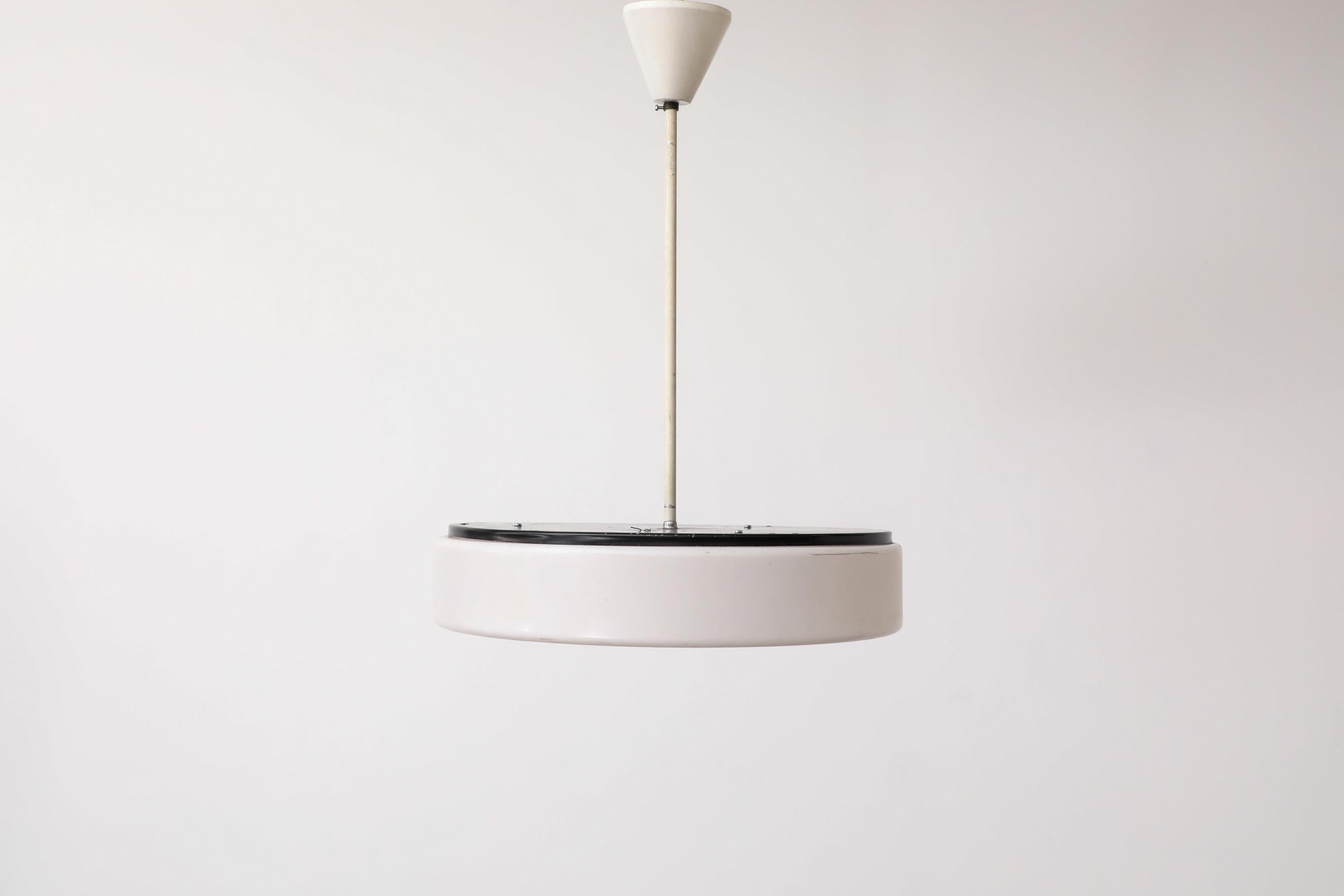 Vintage MOD pill pendant with white plexi glass shade, black enameled frame and original plastic canopy. It takes 3 light bulbs, LED recommended, as high wattage incandescent bulbs could melt the shade. In original condition with visible wear,