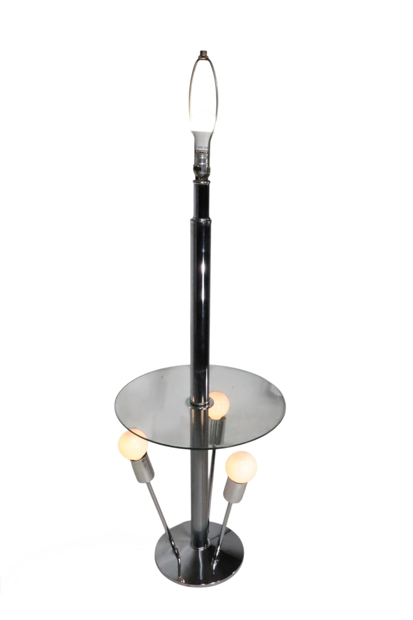 Totally cool Modernist, Space Age, Mid Century combination floor lamp, table. The lamp features a tubular chrome vertical pole which supports a disk form glass shelf table top surface, over four sputnik like lights, which radiate from the chrome