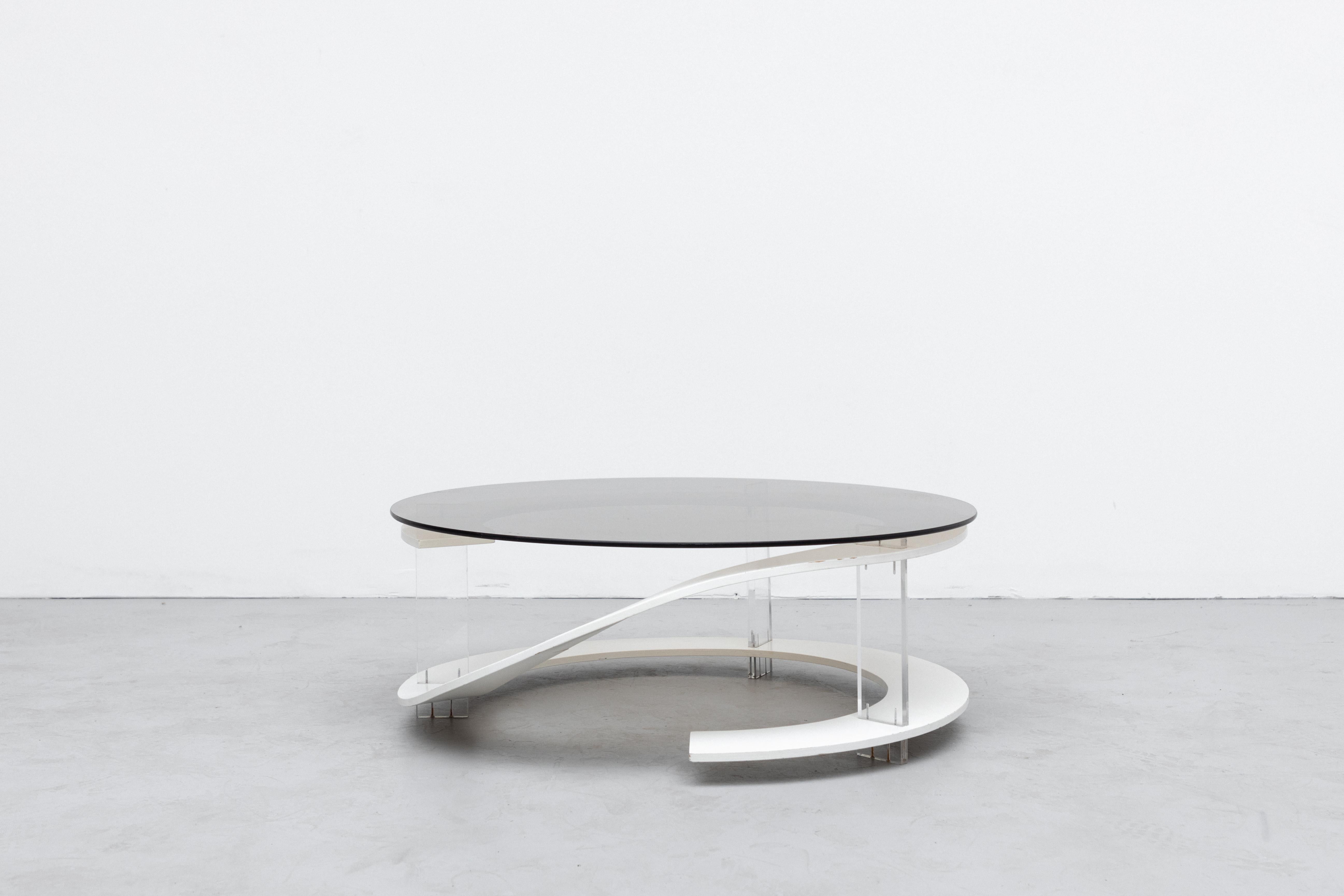 Incredible Space age coffee table with smoked glass top and white stained wood spiral with acrylic supports. unique and stylish design in original condition with some visible scratching to glass and frame. Wear is consistent with age and use.