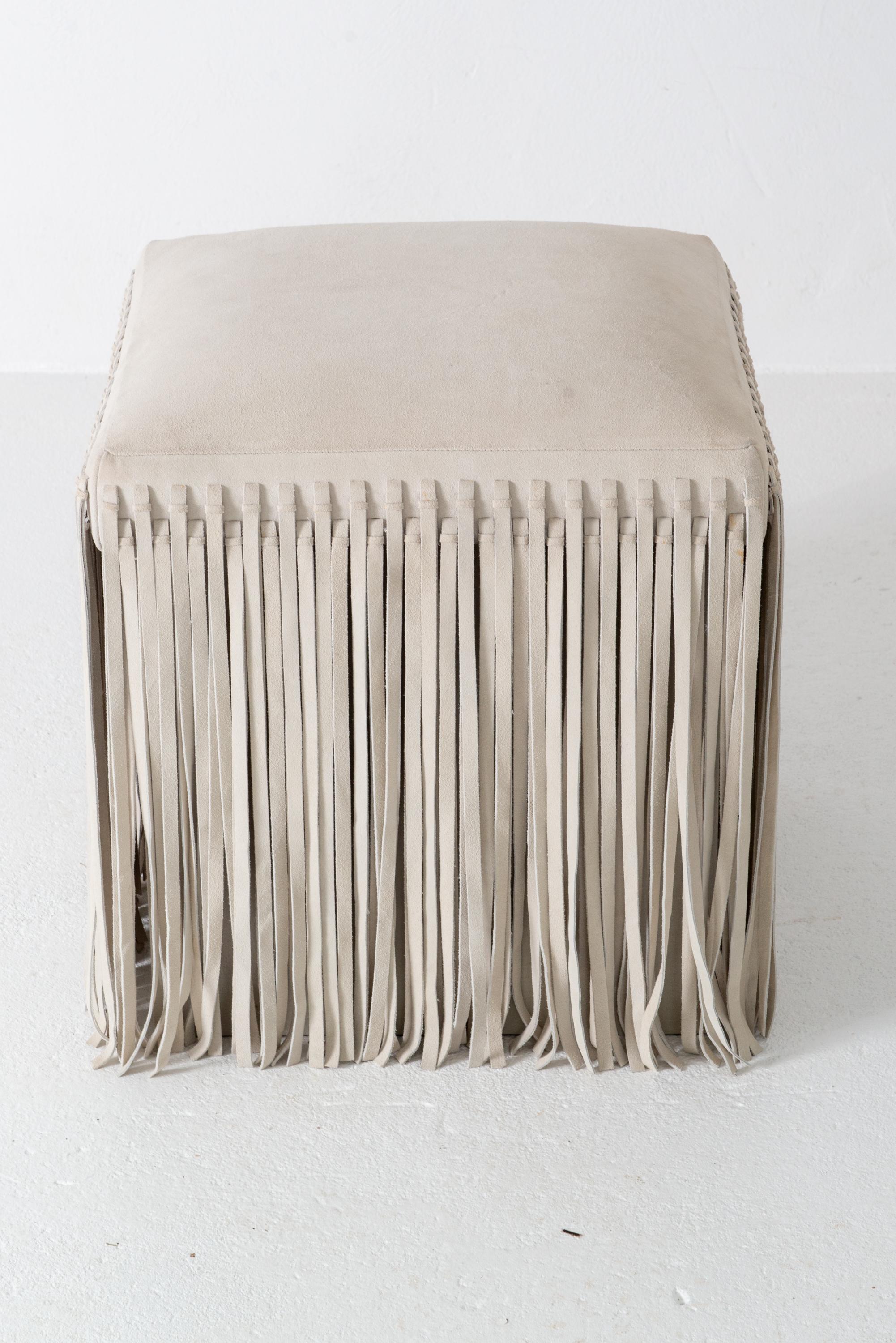 A fun Mod style square off-white suede ottoman with floor length suede fringe. It is 17.5