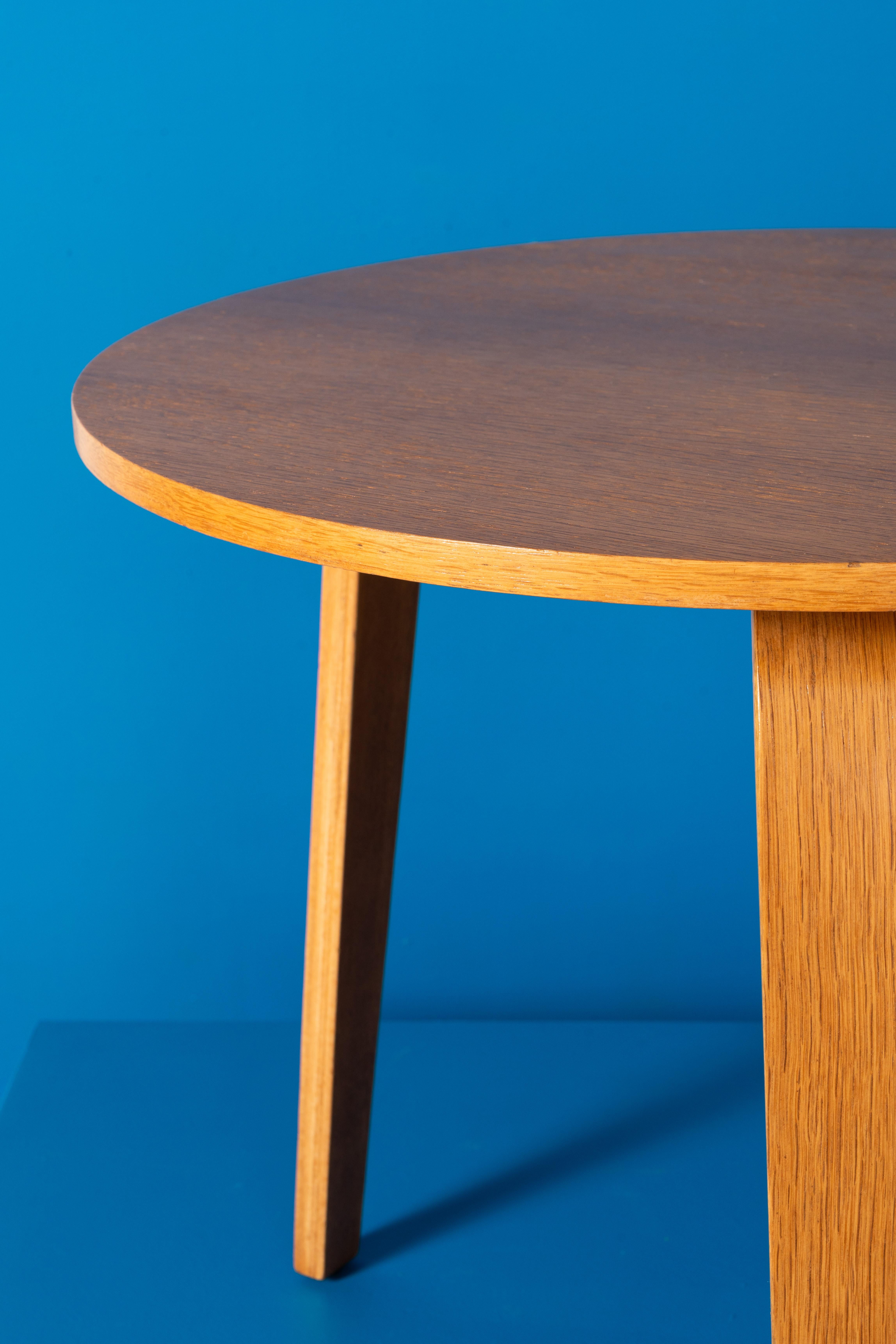 TE07 table, created by Cees Braakman for Pastoe in 1952. Distinguished by its three curved wooden legs securing the Braakman detail, this piece combines elegance with everyday functionality. The tabletop, crafted from wood and plywood with a rich