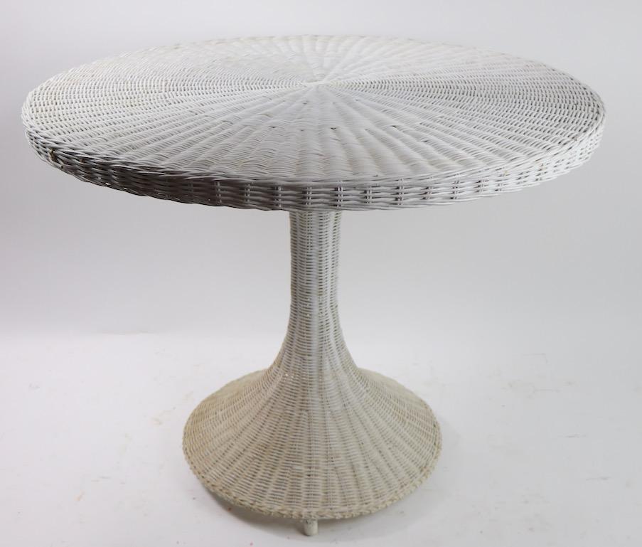 Cool modern design pedestal dining table in woven wicker. Modernist wicker pieces are not often seen or available on the market. Suitable for use as a dining table, or center or game table as well. Design influenced by Saarinen, possibly Lloyd Loom