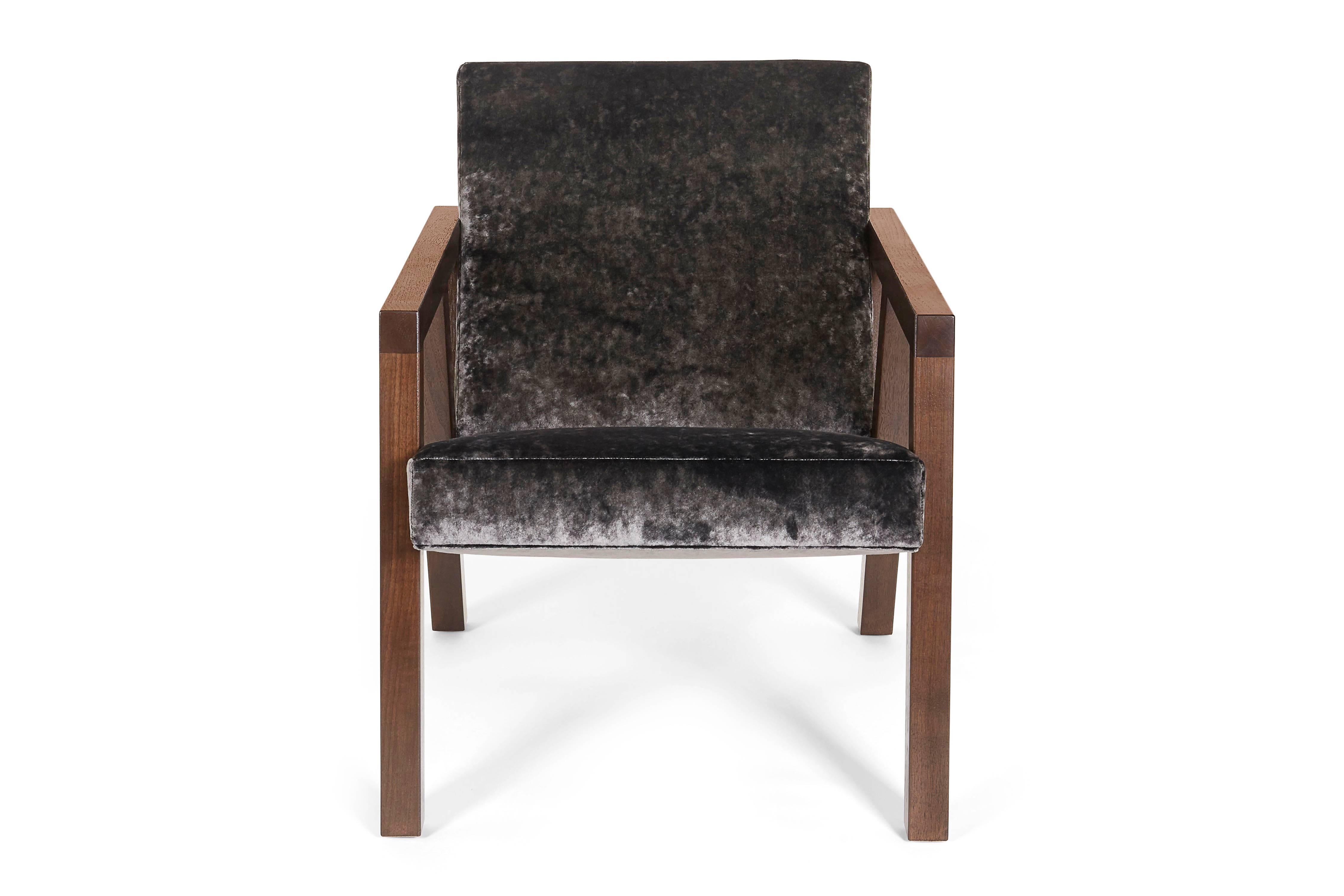 Der moda Stuhl ist zeitlos und modern zugleich. Mit seinen schlanken, kantigen Armen und Beinen aus Walnussholz und dem plüschigen Samtbezug ist er sowohl funktional als auch schick.