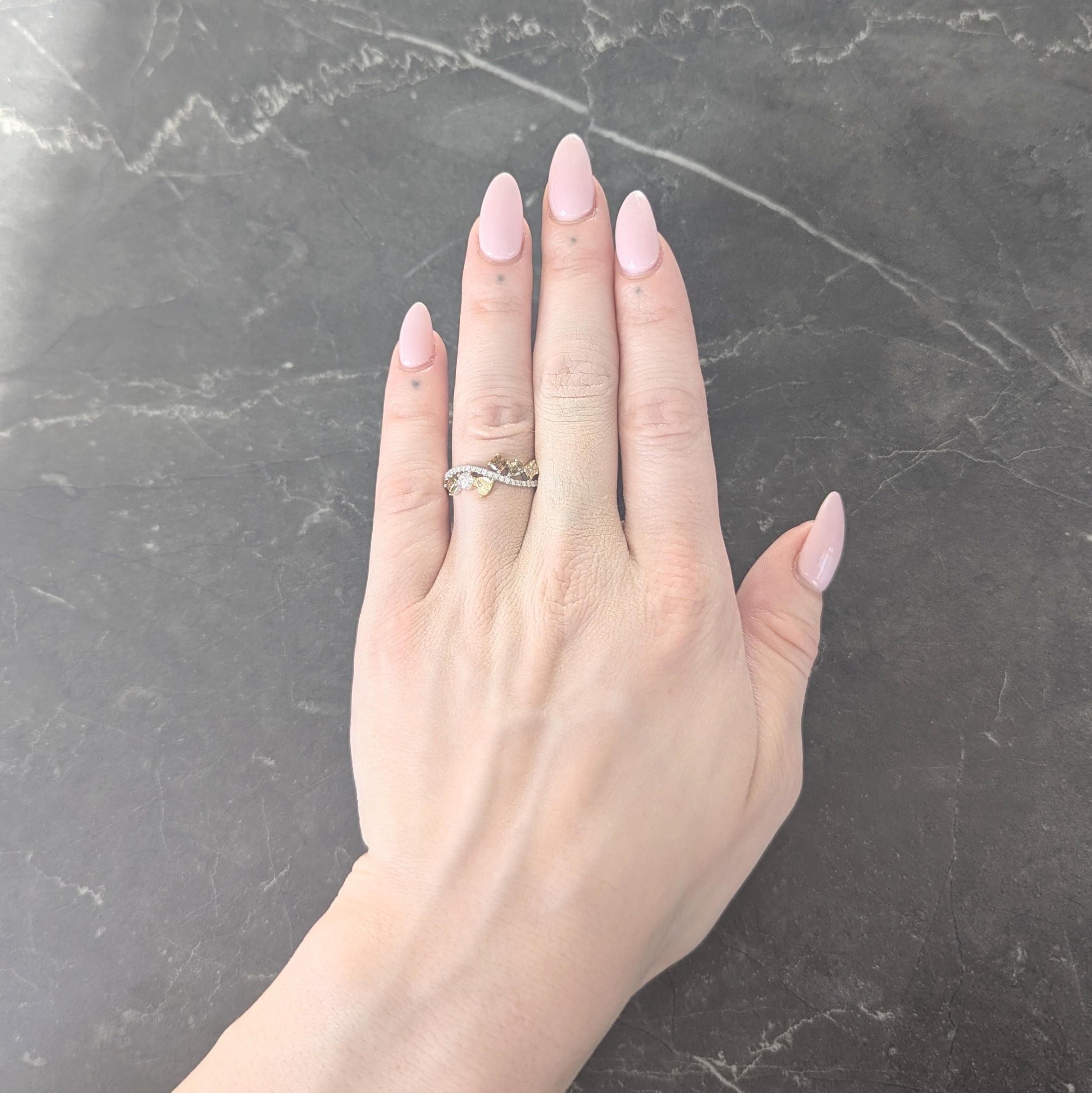 Designed as a curved white gold band with a central row of prong set round brilliant cut diamonds
Weighing approximately 0.10 carat total - G/H color with VS2 clarity
Juxtaposed with clusters of diamonds each prong set in yellow and white gold