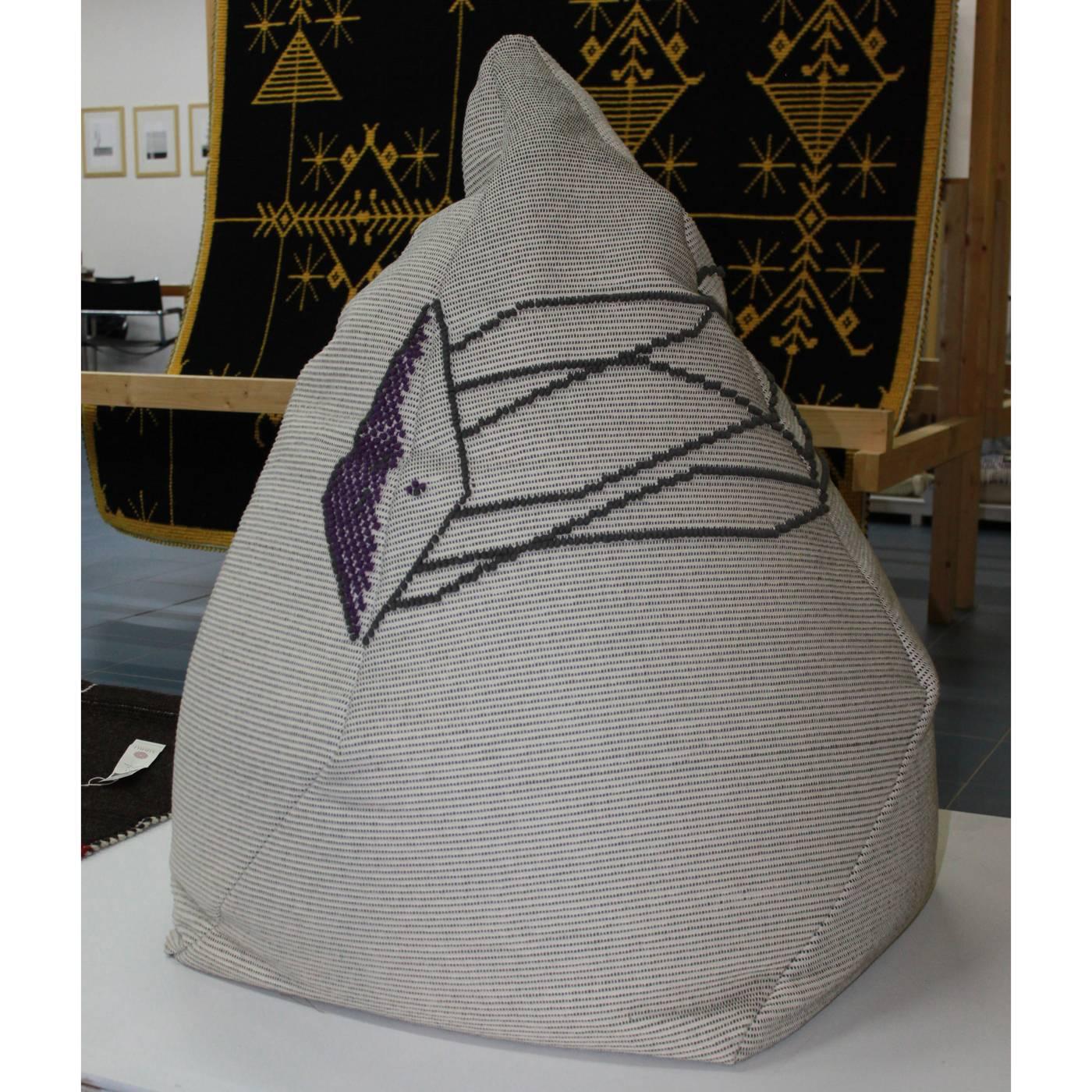 This unique piece was born from the idea of giving the seat a tridimensionality. Its shape is deconstructed and becomes almost conical, but soft. The colors are natural, with a geometric purple decoration running irregularly around the top of the