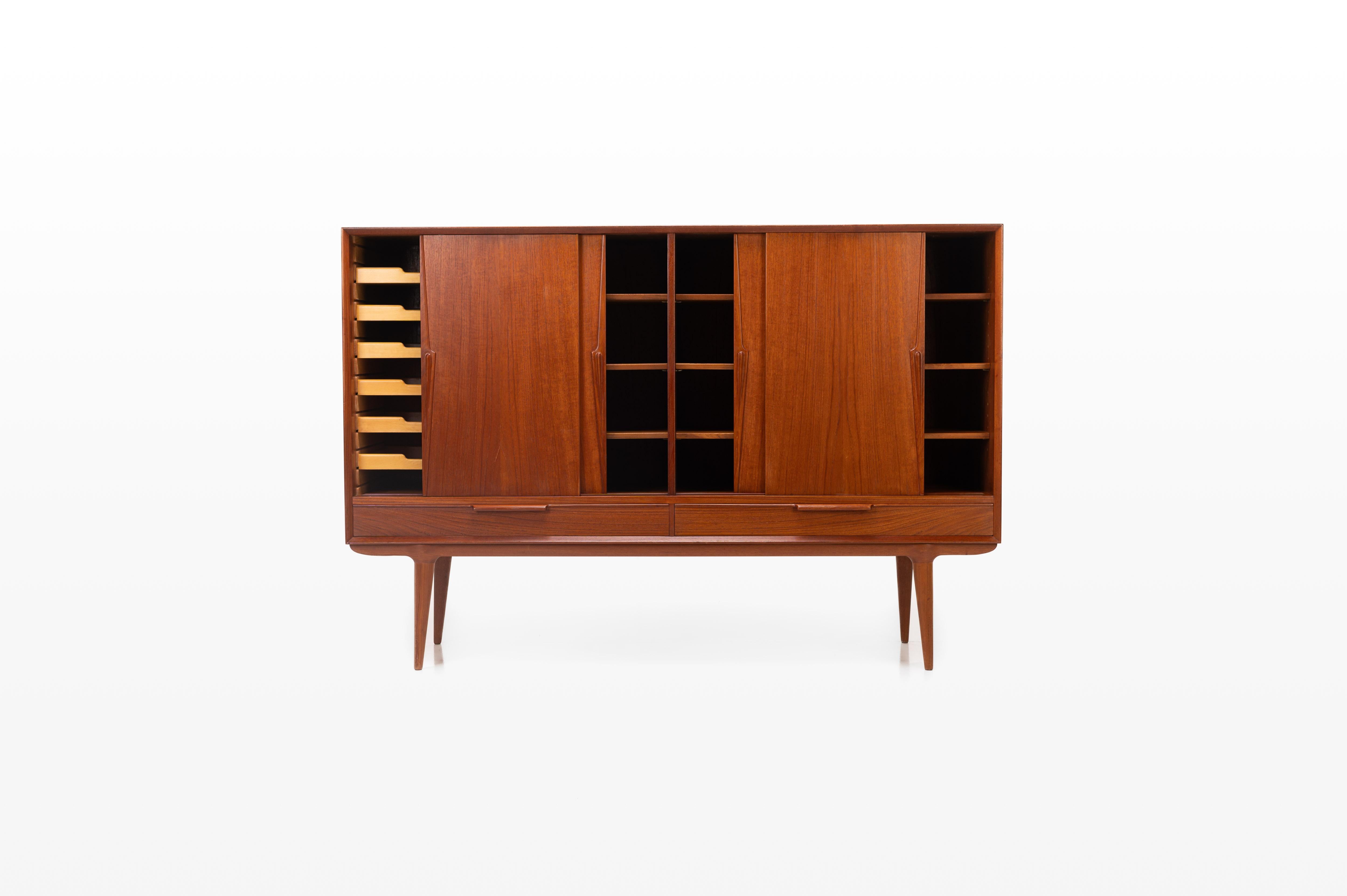 Beautiful teak sideboard from Gunni Omann (Model 13) for Omann Jun Møbelfabrik in Denmark. The sideboard has four sliding doors, 2 drawers and integrated interior drawers. The highboard is in very good condition.