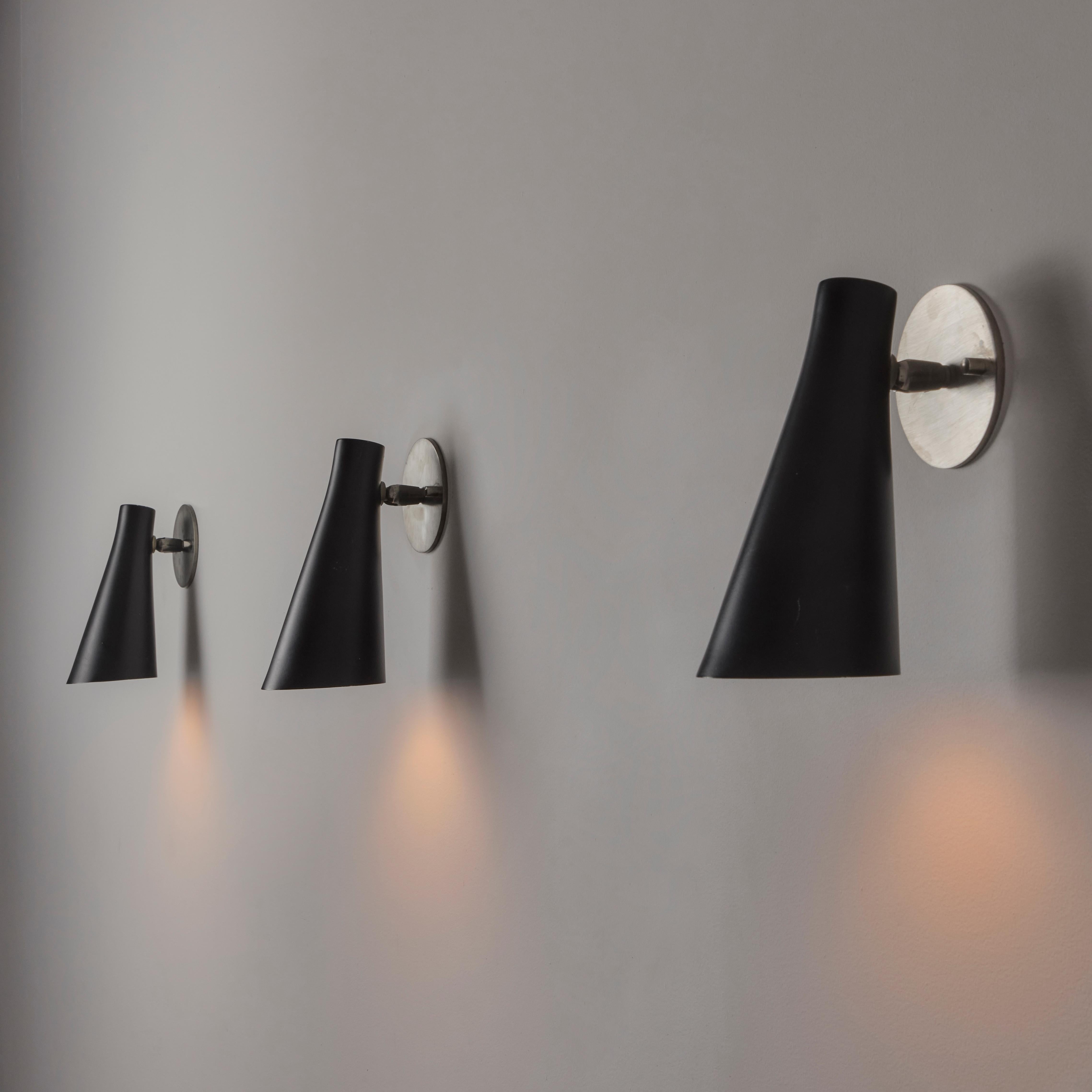 Applique simple modèle 138 par Giuseppe Ostuni pour Oluce. Conçue et fabriquée en Italie, en 1952. Applique conique minimale et classique avec une finition émaillée. L'accouplement pivotant situé à la base de la plaque de montage permet à