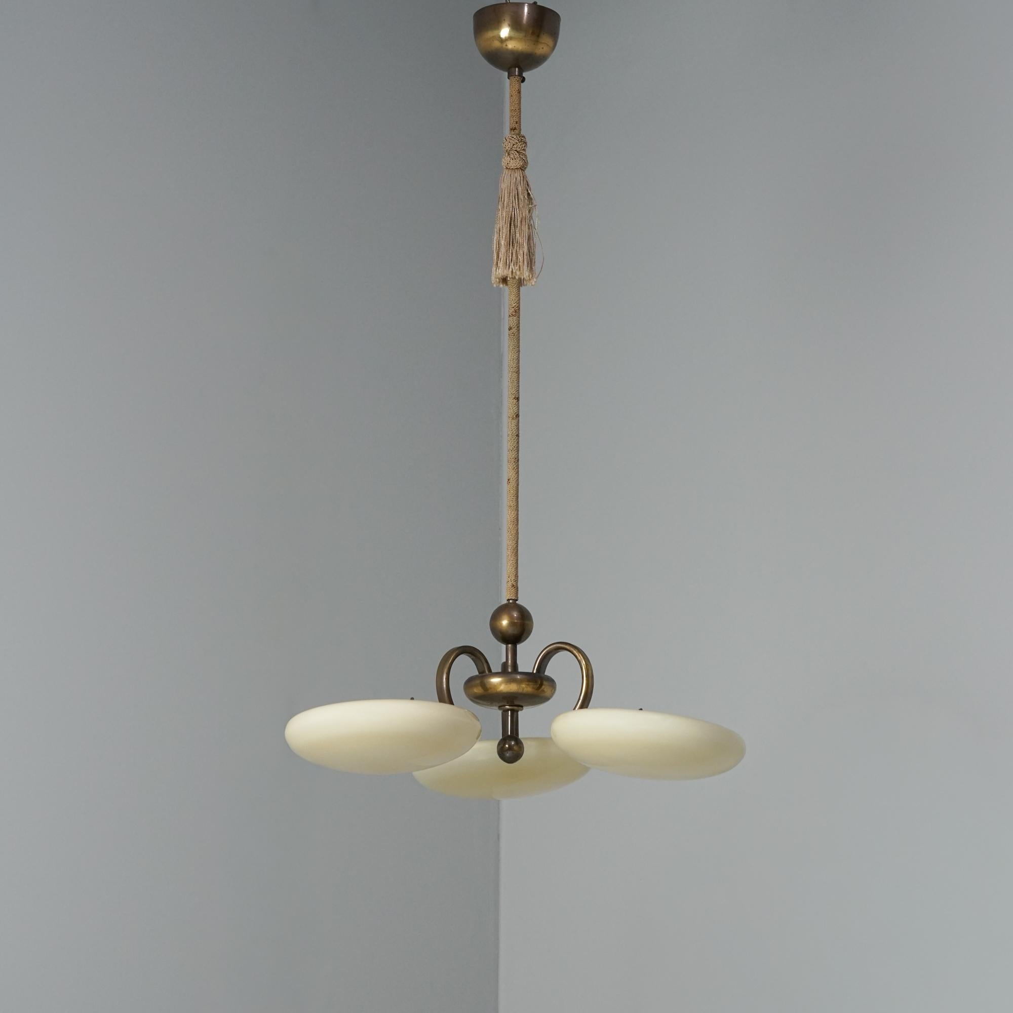 Colgante modelo 1425, diseñado por Paavo Tynell, fabricado por Taito Oy, años 1930/1940. Armazón de latón, envoltura de cuerda, tulipas de cristal opalino. Buen estado vintage, pequeña pátina. Faltan pequeños trozos de cristal en el borde donde el